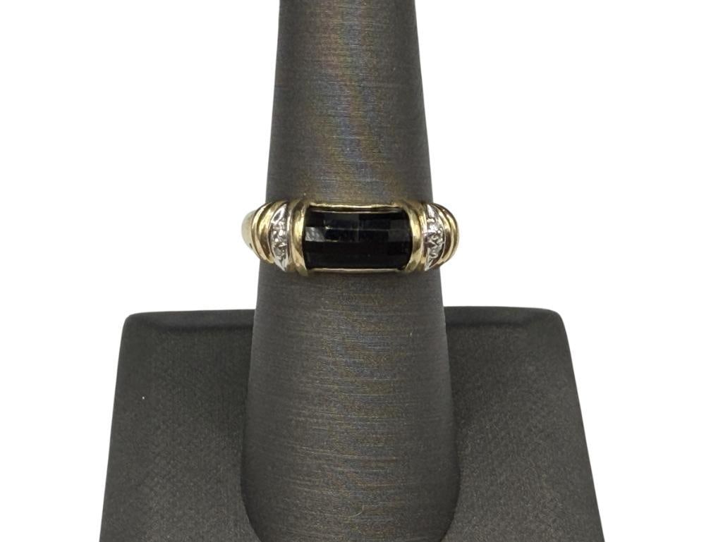 10K YELLOW GOLD FACETED ONYX AND DIAMOND RING: FEATURING UNIQUE FACETED ONYX SET IN CENTER OF TWO SMALL DIAMONDS, DESIGNER HALLMARKED SIZE 7 1/4, 1/4" FRONT, 3.74 GRAMS, 1MM DIAMONDS, 9MM X 5MM ONYX