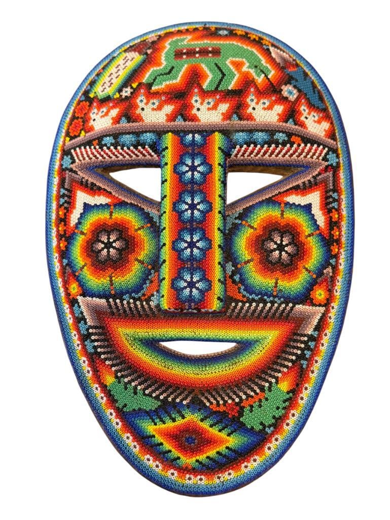 INDIGENOUS WIXARIKA MEXICAN HUICHOL ARTIST JUVENTINO CARILLO HAND BEADED MASK JALISCO, MX: VIBRANT HAND BEADED MASK WITH SYMBOLS OF FLOWERS AND ANIMALS, SIGNED ON THE BACK, IN GOOD CONDITION NO WEAR OR MISSING BEADS 12 3/8" X 7 7/8"