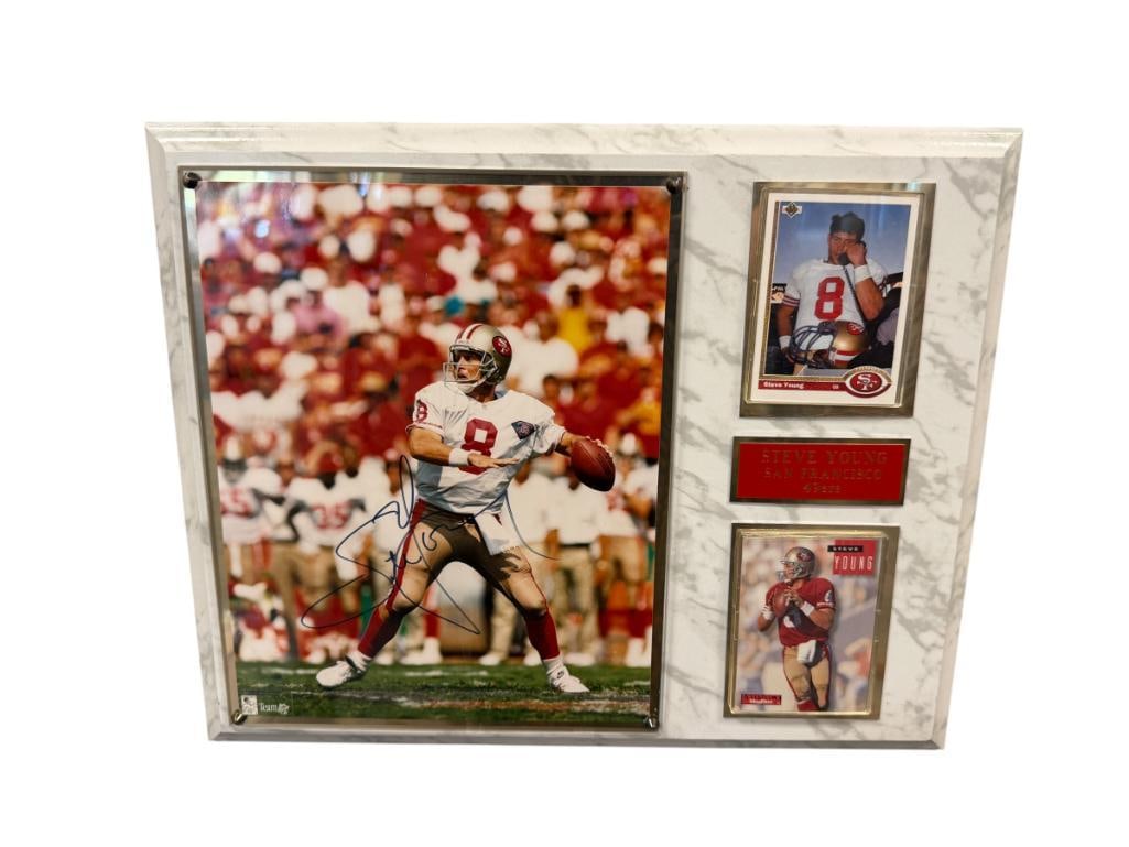 STEVE YOUNG HALL OF FAMER AUTOGRAPHED PLAUE: PLAQUE FEATURES STEVE YOUNG AUTOGRAPHED PHOTO, 1991 UPPERDECK AND 1994 SKYBOX SPORT CARDS, COPY OF CERTIFICATE OF AUTHENTICITY ON THE BACK FROM SPORTS CARDS ETC MISSION VIEJO, CA 15" X 12"