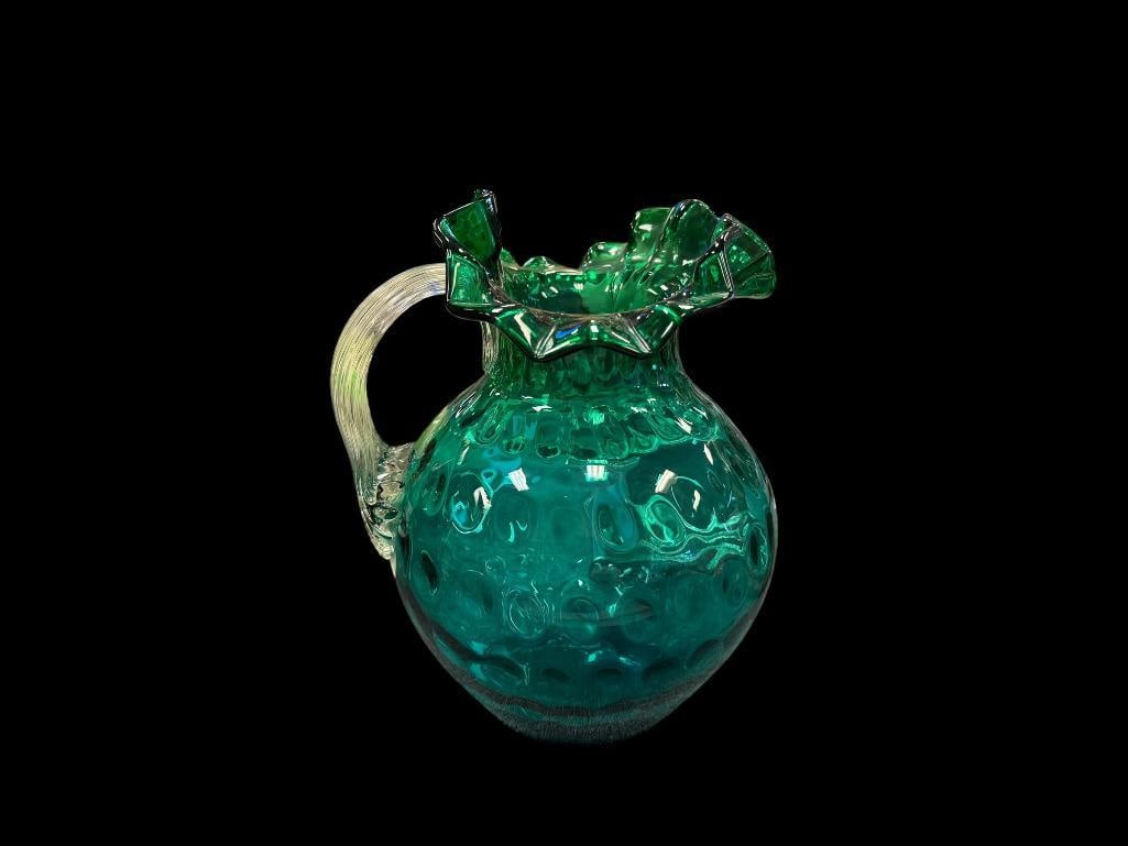 EMERALD GREEN FENTON RUFFLED RIM "FENTON" THUMBPRINT PITCHER HAND BLOWN ART GLASS: BULBOUS PITCHER WITH RUFFLED RIM AND APPLIED CLEAR HANDLE, NO CHIPS OR CRACKS 9" H