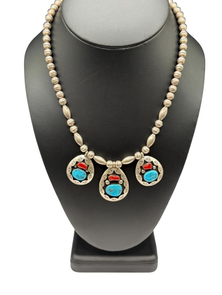 NAVAJO TEDDY GOODLUCK ARTIST SIGNED STERLING SILVER TURQUOISE AND CORAL NECKLACE: FEATURING THREE SHADOWBOX PENDANTS ACCENTED WITH STAMP DESIGN, TURQUOISE, AND CORAL, SIGNED BY ARTIST "TG" IN CLOVER 17" X 1/4" NECKLACE, UP TO 1 3/8" PENDANTS, 27.08 GRAMS