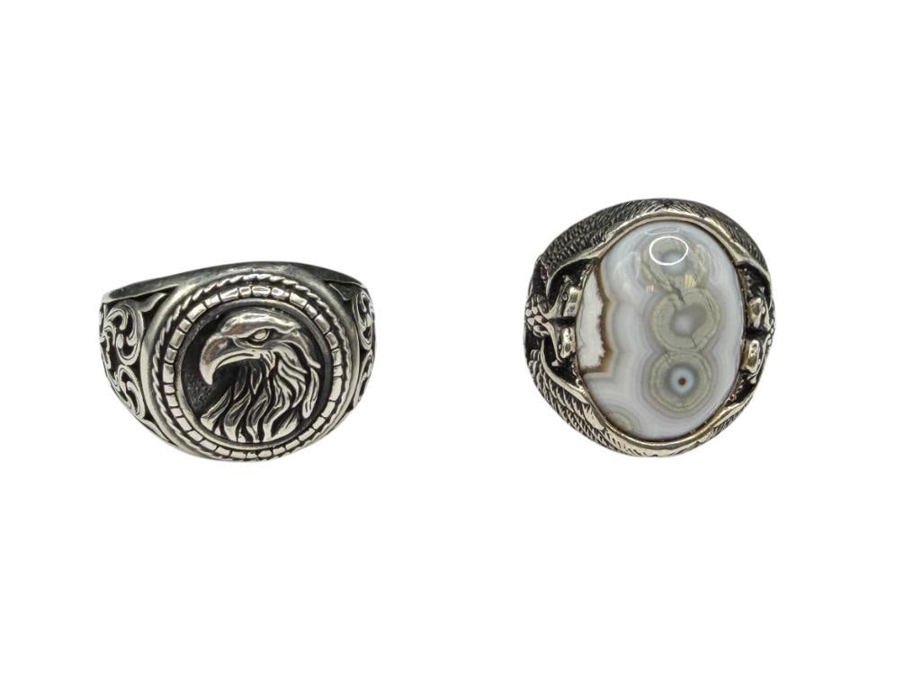 TWO MEN'S STERLING SILVER EAGLE MOTIF RINGS INCLUDING ONE WITH NATURAL EYE AGATE CABOCHON: BOTH FEATURE EXCEPTIONAL DETAIL SIZE 8 AND 14, LARGEST HAS 1" FRONT, 19MM X 15MM NATURAL EYE AGATE, 26.74 GRAMS