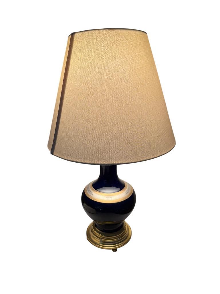 VINTAGE MARBRO LAMP CO. COBALT BLUE GLAZED PORCELAIN LAMP WITH GOLD AND SILVER ETCHED BAND: FOOTED AND STEPPED ROUND BASE, MADE IN LOS ANGELES, CA, WITH LINEN SHADE, TESTED + 21" H