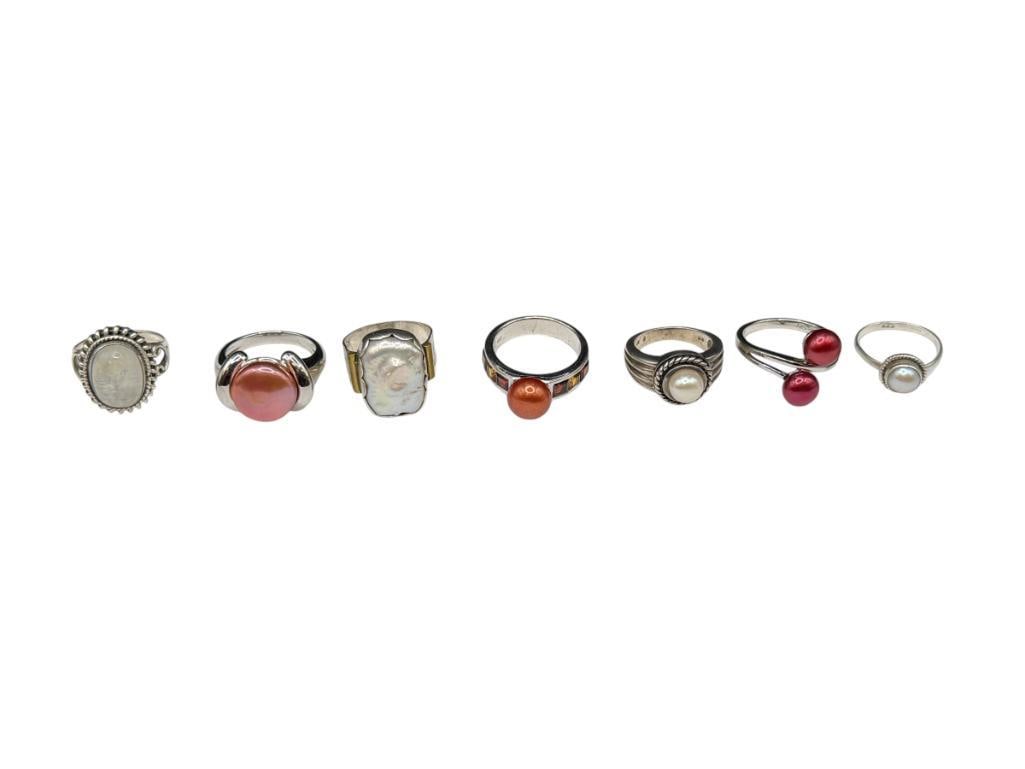 SEVEN STERLING SILVER RINGS INCLUDING MOST WITH PEARLS: FEATURING VARIOUS COLORED PEARLS, CABOCHON MOONSTONE, AND MABE PEARL RING, SOME SIGNED BY MAKER VARIOUS SIZES, 43.89 GRAMS