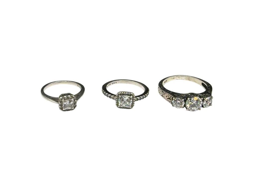 THREE STERLING SILVER CZ ENGAGEMENT STYLE RINGS: ONE WITH ELABORATE PIERCED FILIGREE DESIGN, INCLUDES ROUND CUT, PRINCESS CUT, AND CUSHION CUT CZS VARIOUS SIZES, 9.12 GRAMS