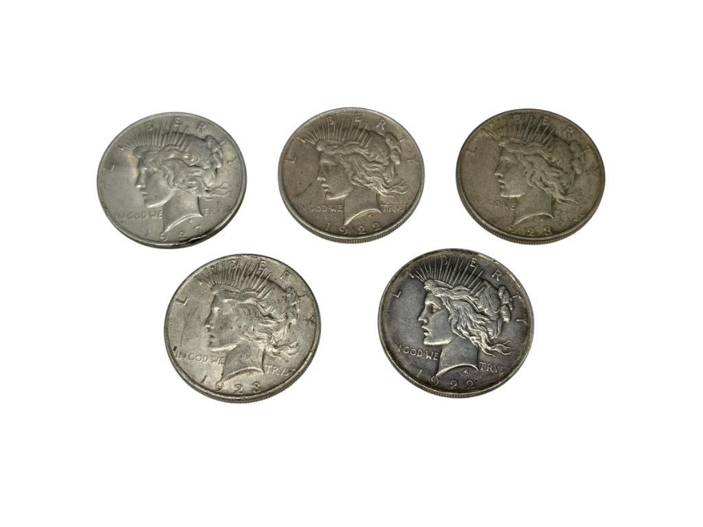 FIVE U.S. PEACE SILVER DOLLARS FEATURING VARIOUS DATES AND MINT MARKS: TWO 1922, TWO 1923-S, AND ONE 1927-D, 90% SILVER