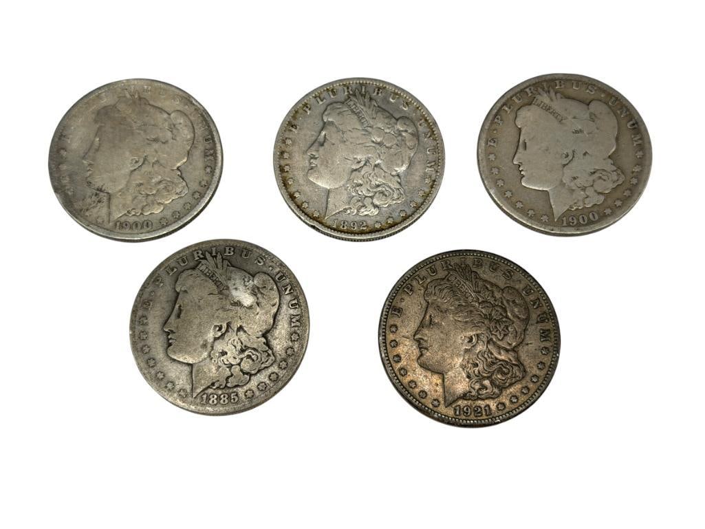 FIVE U.S. MORGAN SILVER DOLLARS FEATURING VARIOUS DATES AND MINT MARKS: INCLUDES 1885-O, 1892-O, TWO 1900-O, AND A 1921-S, 90% SILVER