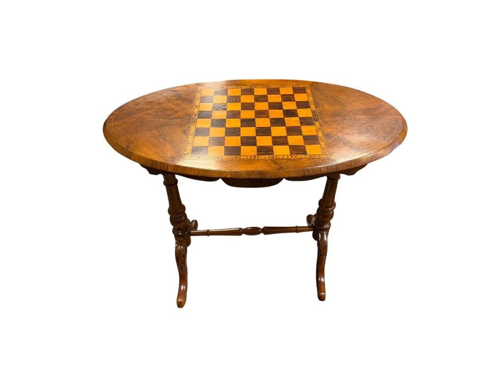 VINTAGE OVAL WOODEN CHESS / GAME TABLE WITH DISTINCT INLAID CHESSBOARD TOP: CARVED AND TURNED SUPPORT LEGS WITH LEAF CARVINGS, SOME LIGHT DAMAGE ON TOP 34" X 19" X 27"