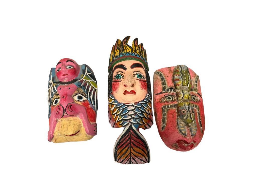 THREE VINTAGE HAND CRAFTED WOODEN POLYCHROME MASKS MADE IN MEXICO: STYLIZED FACE MASK WITH CARVED INSECT ON TOP, FEMALE FACE FISH MASK WITH COLORFUL CARVED SCALES, AND WINGED FIGURE MASK, 9", 10", AND 15" H