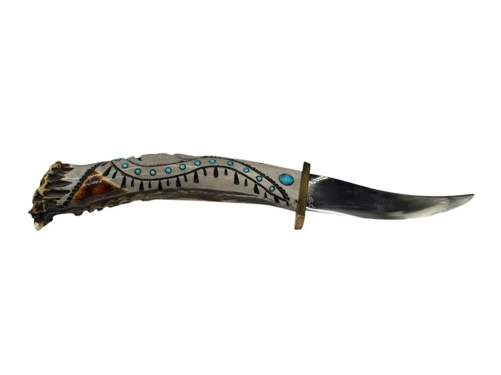 NATIVE AMERICAN MADE STAG HANDLED FIXED BLADE KNIFE FEATURING CHIEF AND BEAR PAW MOTIF ON HANDLE: HANDLE IS CARVED ANTLER WITH EXCEPTIONAL DETAIL AND ACCENTED WITH TURQUOISE, CURVED BLADE MARKED WITH NUMBERS AT BASE 3 3/4" BLADE, 9 3/4" TOTAL LENGTH