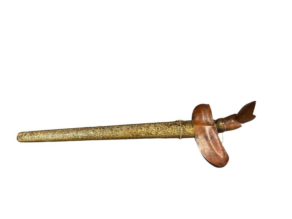 ANTIQUE INDONESIAN KERIS DAGGER WITH CARVED HANDLE AND ELABORATE BRASS SHEATH JAVANESE / MADURESE: PISTOL GRIP CURVED WOODEN HANDLE WITH LONG THIN BLADE, HAND CHASED BRASS SHEATH WITH WOOD TOP 19" L
