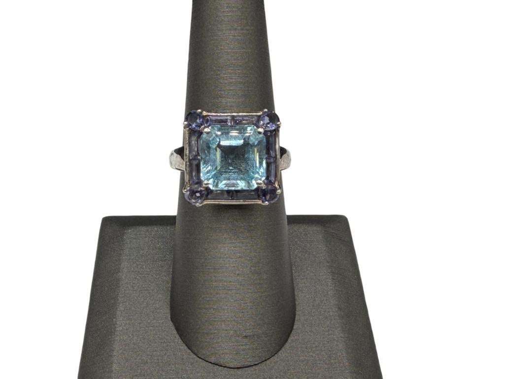 STERLING SILVER CUSHION CUT BLUE TOPAZ AND IOLITE FASHION RING: RING FEATURES A BLUE TOPAZ SURROUNDED BY AN IOLITE BORDER, DESIGNER HALLMARKED SIZE 7 1/4, 5/8" FRONT, 10MM X 10MM TOPAZ, 5.56 GRAMS