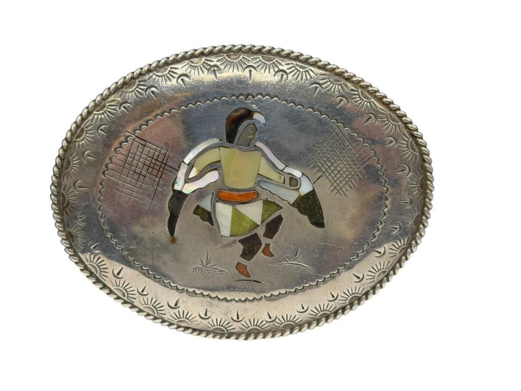 NAVAJO ROBERT BECENTI ARTIST SIGNED STERLING SILVER INLAID THUNDERBIRD DANCER BELT BUCKLE: FEATURING INLAID MOTHER OF PEARL AND OTHER STONE THUNDERBIRD DANCER SURROUNDED BY STAMPED BORDER, SIGNED BY ARTIST " RB NAVAJO" 4", 91.52 GRAMS