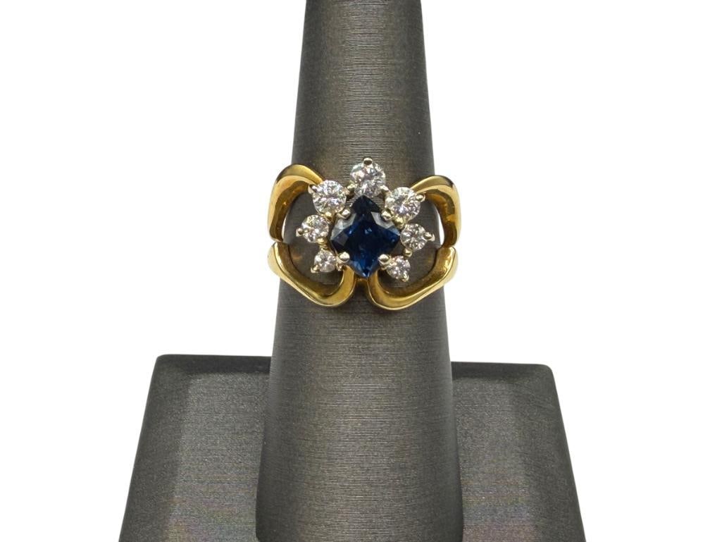 14K YELLOW GOLD BLUE SAPPHIRE AND ROUND BRILLIANT CUT DIAMOND FASHION RING: FEATURING A UNIQUELY SLANTED SQUARE CUT BLUE SAPPHIRE ACCENTED BY SEVEN ROUND BRILLIANT CUT DIAMONDS GRADUATING IN SIZE SIZE 7, 5/8" FRONT, 6MM X 6MM SAPPHIRE, 1.55CT SAPPHIRE, UP TO 3.5MM DIAMONDS,