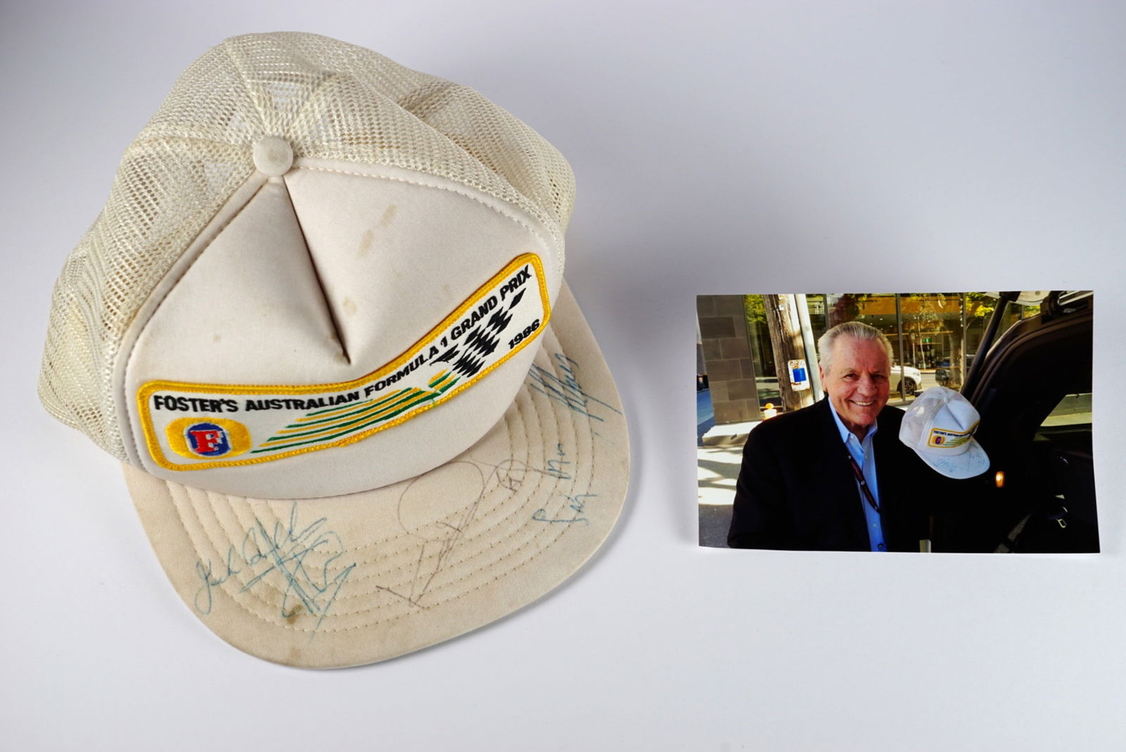 AUSTRALIAN GRAND PRIX: An original white 1986 FOSTER'S AUSTRALIAN F1 GRAND PRIX cap. Signed: AUSTRALIAN GRAND PRIX: An original white 1986 FOSTER'S AUSTRALIAN FORMULA 1 GRAND PRIX white cap, visor signed by numerous Formula 1 drivers including Sir Jack Brabham, Alan Jones, Stirling Moss, Keke