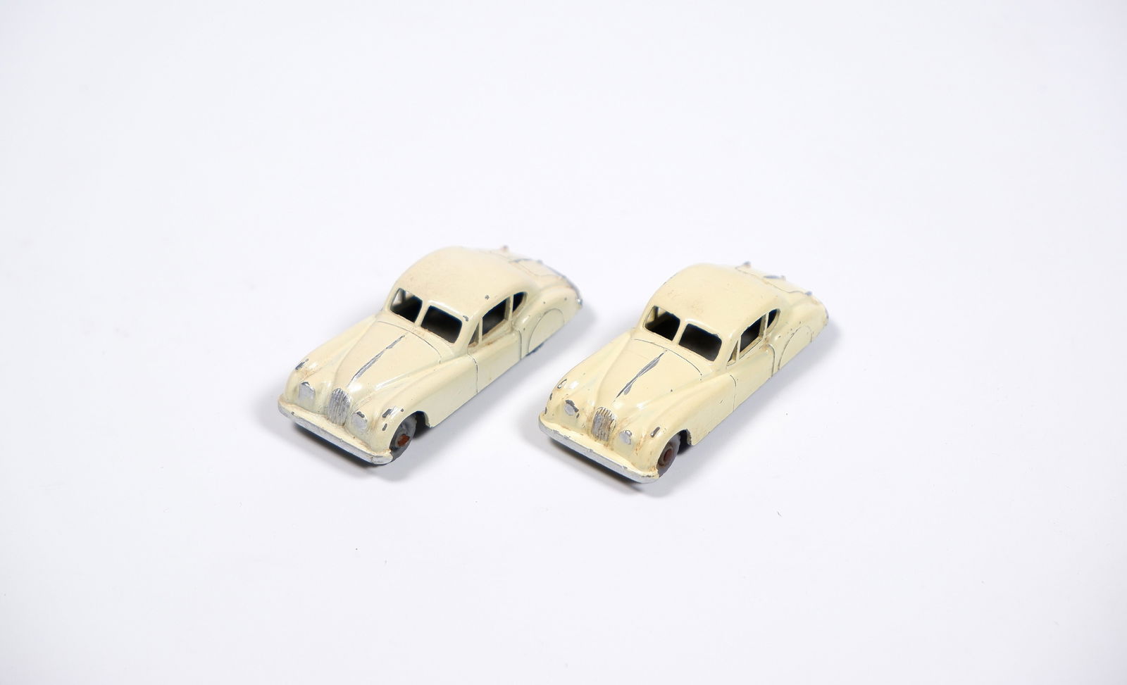 JAGUAR: Two Matchbox Regular Wheels Jaguar XK140's in cream. GPW & MW: JAGUAR: Two Matchbox Regular Wheels Jaguar XK140's in cream, one with grey plastic wheels, other with metal wheels, black bases; models with paint chips.