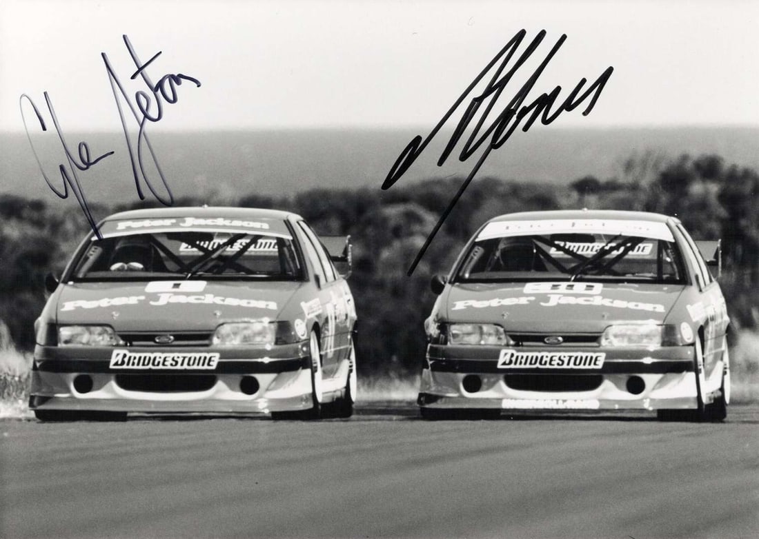 JONES/SETON: Image of team drivers A.Jones and G.Seton each driving a PJR EB Ford Falcon. Signed: JONES/SETON: A black and white image of team drivers Alan Jones and Glenn Seton each driving a Peter Jackson EB Ford Falcon, image signed by both drivers; on thick stock paper, image measures approxim