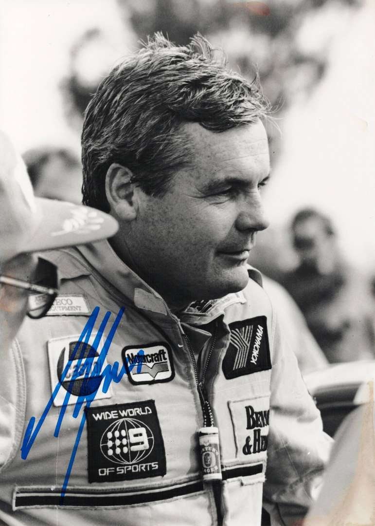 JONES: A black and white portrait photo of Alan Jones by Julia Horvath. Jones signature: JONES: A black and white portrait photo of Alan Jones by Julia Horvath, taken at Winton, 1990, image with slight tanning to lower right corner, image signed by Jones; on thick stock paper, image measu