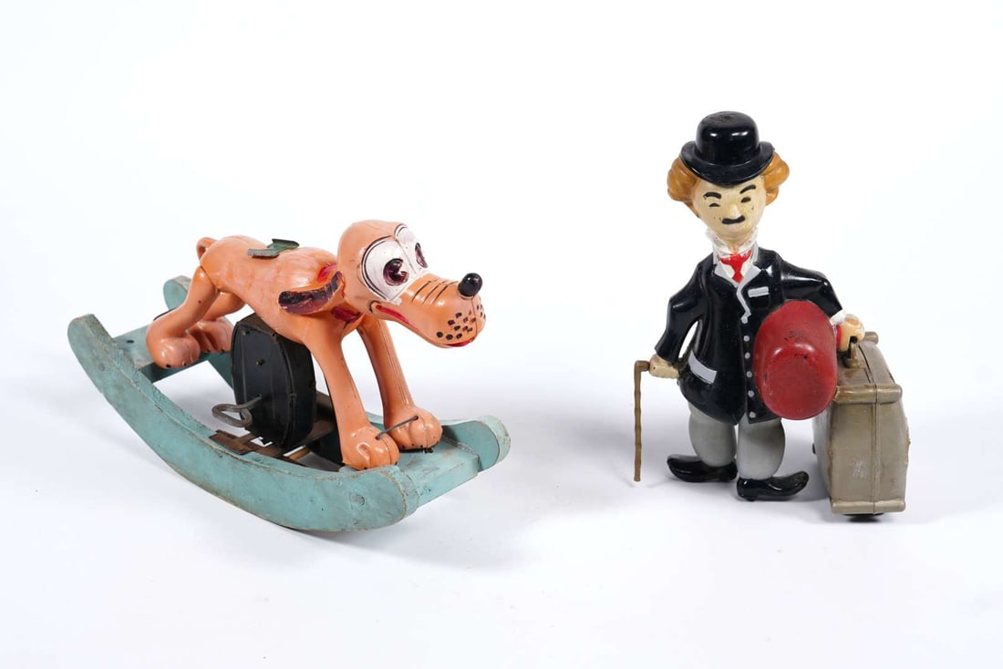 Two vintage clockwork toys, Pluto and Charlie Chaplin: Two vintage clockwork toys, Pluto and Charlie Chaplin Pluto lacking rider, mechanism appears to be working, small crack to left ear Charlie Chaplin, made in Spain, crack to suitcase