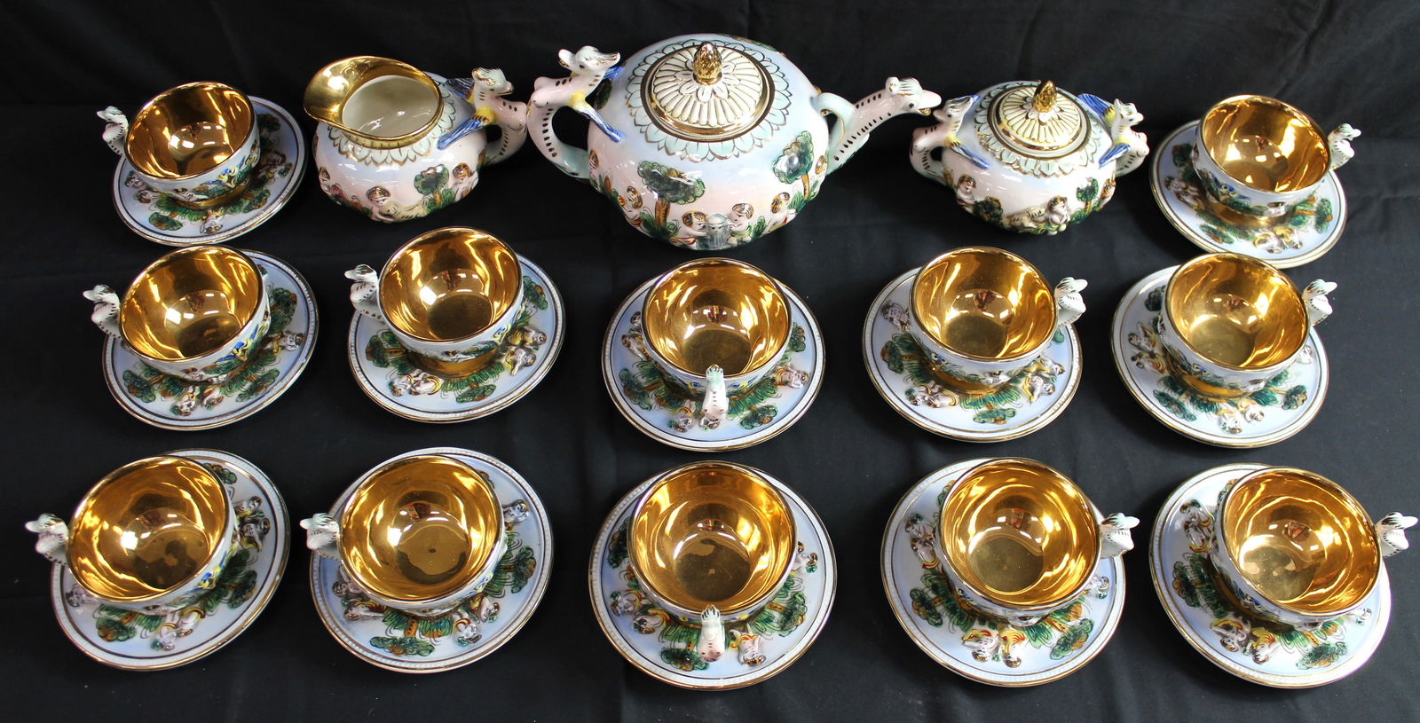 DRS Capodimonte 659 Grotesque Tea Set: DRS 659 Grotesque Tea set. This is a teaset made in italy full of color and has unique figure desgins as the handles, this set consists of 12 teacups, 12 saucers, 1 creamer, 1 sugar bowl, and 1 teapot