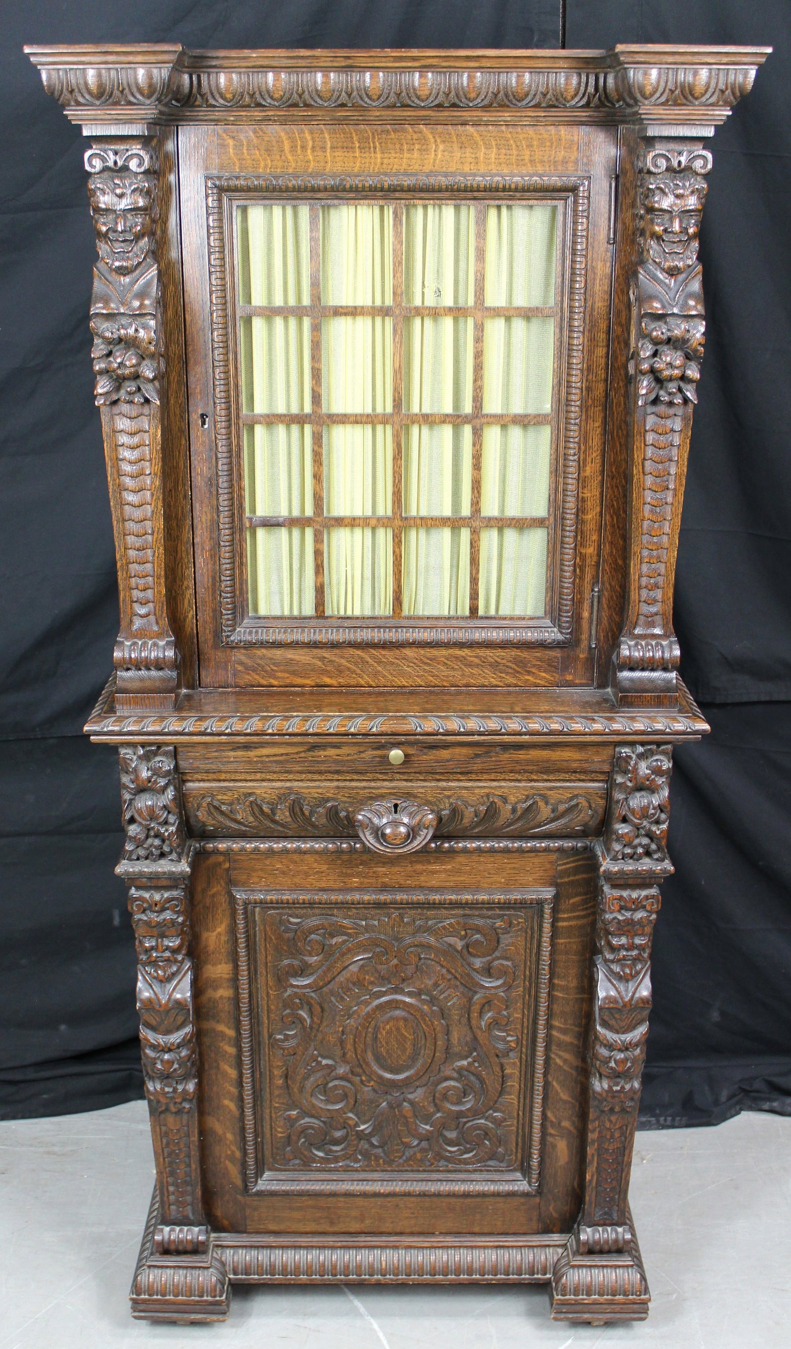Antique Carved Cabinet with Hidden Compartments and Safe: Antique Ornately Carved Cabinet with Safe. Cabinet has two carved bacchus grotesque style upper supports along with two lower carved supports of scholars atop two fanged grotesques with hidden compart