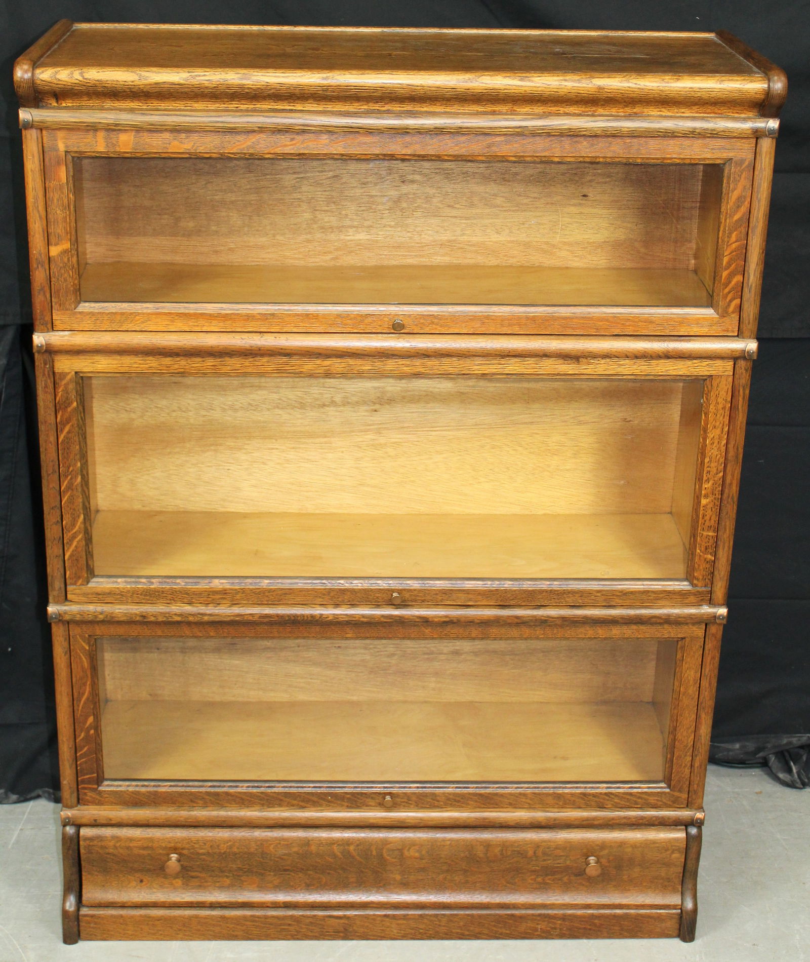 Macey Barrister Sectional Oak Bookcase: Macey Barrister Sectional Oak Bookcase. This is 5 piece barrister consisting of the top unit, three barrister units, and the bottom unit with drawer. The measurements are 47" tall x 12 x 34" wide x 12