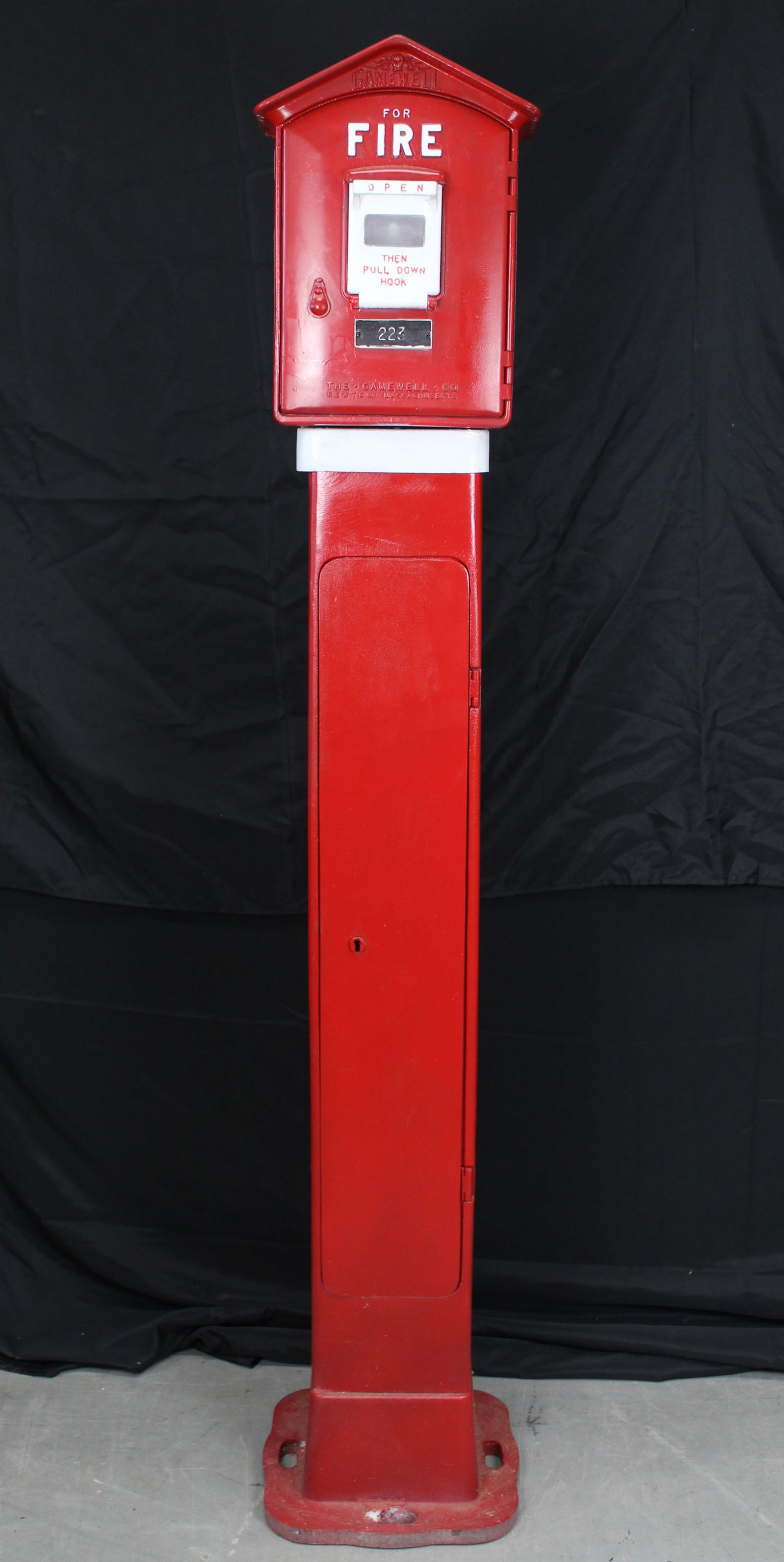 Gamewell Fire Alarm Box on Pedestal: Gamewell Fire Alarm Box on Pedestal. 1900s red and white fire box made by the Gamewell Co. In Newton Massachusetts. It has a white pull handle and says "fire" in white letters. Inside has the white