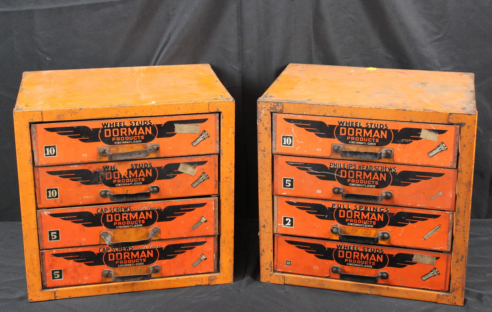 Pair of Dorman Wheel Studs Metal Cabinets: Pair of Dorman Wheel Studs Metal Cabinets. Pair of bright orange Dorman wheel studs cabinets, each cabinet has four drawers with a Dorman label on each one. Inside the drawers are metal dividers with