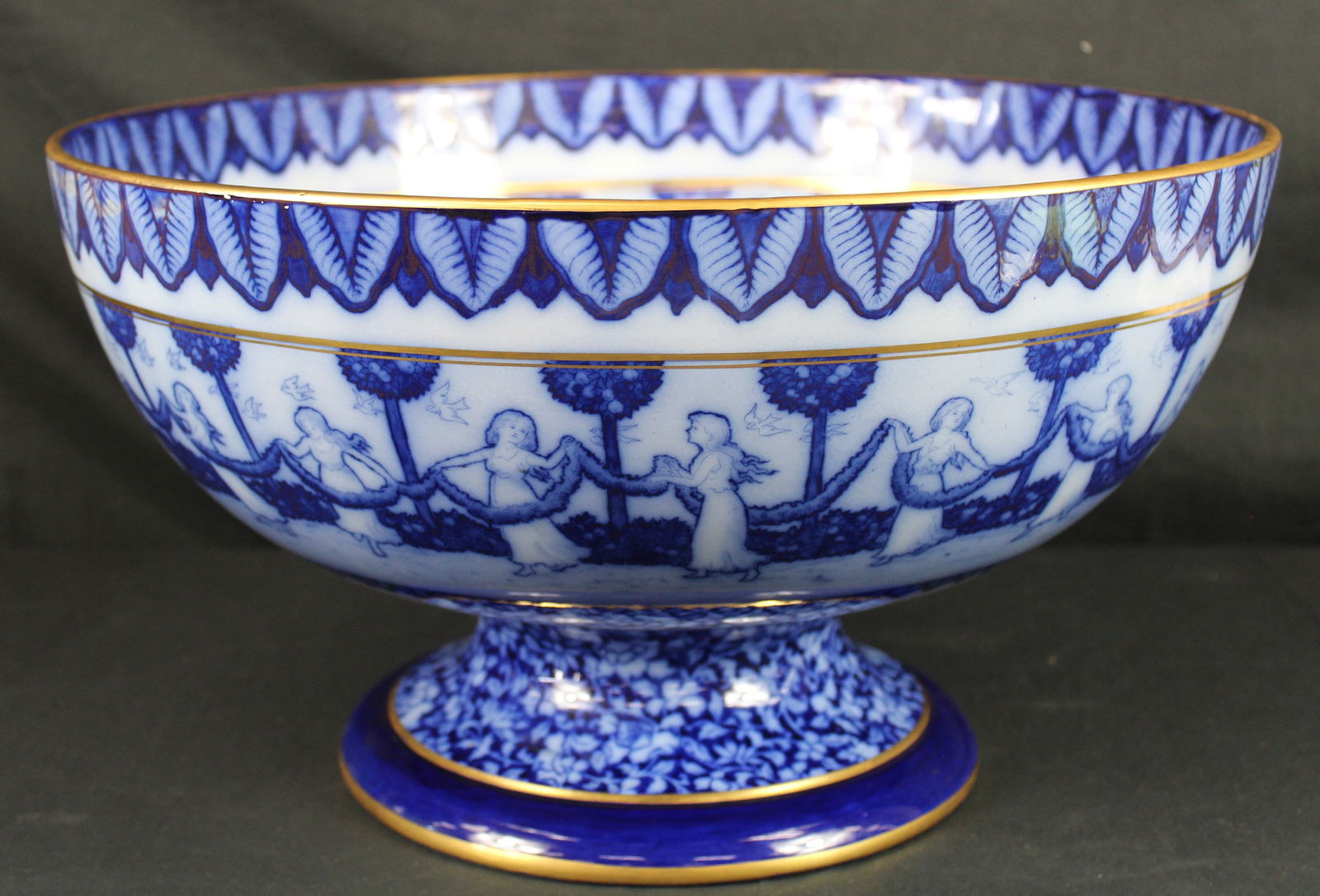 Antique Royal Doulton Burslem Morrisian Flow Blue Large Compote: Antique Royal Doulton Burslem Morrisian Flow Blue Large Compote. Beautiful Royal Doulton compote with blue floral designs and a scene around the outside and inside of the bowl of women in what appears