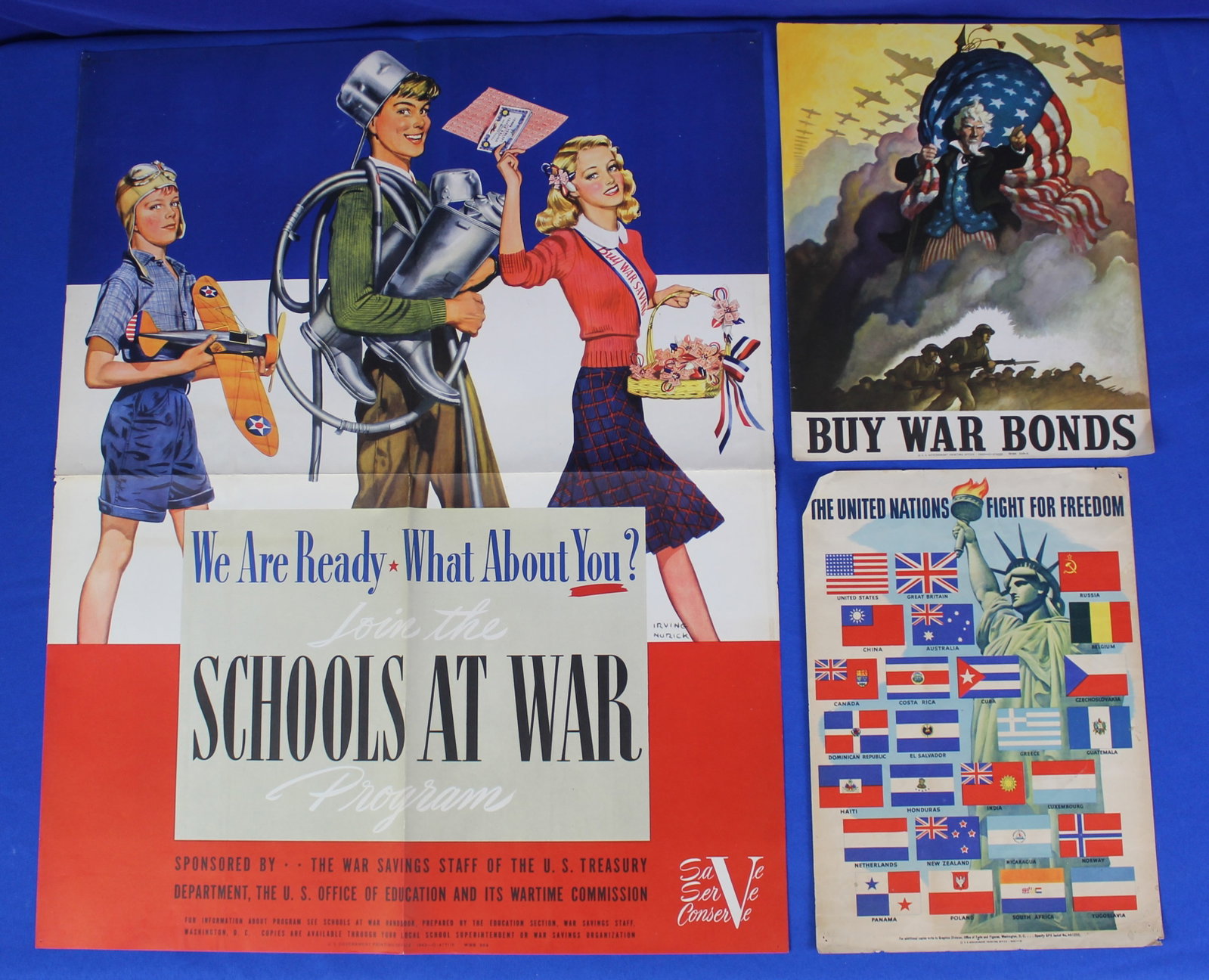 WWII "Buy War Bonds", "Schools at War" and UN Freedom Posters (1P): Lot of 3 original 1942 WWII posters featuring a WSS 510-A Buy War Bonds poster, a Schools at War poster, and a jacket No. 461205 the United Nations Fight For Freedom poster. The buy war bonds has a li