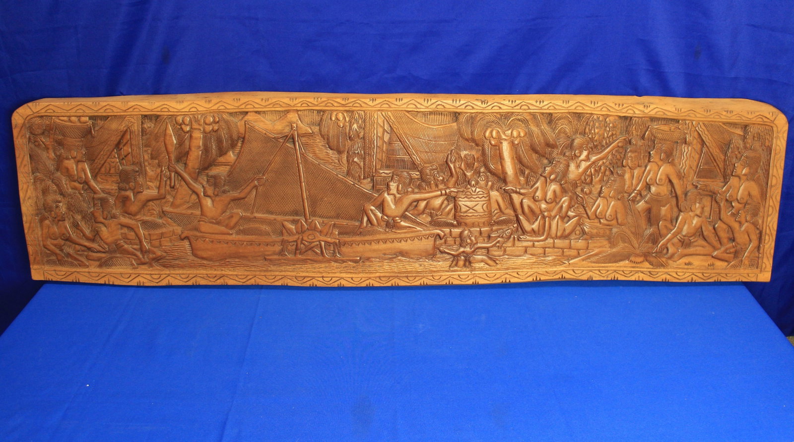 Large Carved Wood Panel: Large African light wood carved panel depicting a port with people in boats and on docks moving goods. The panel has some light fading along the top, but overall the wood panel is in very good