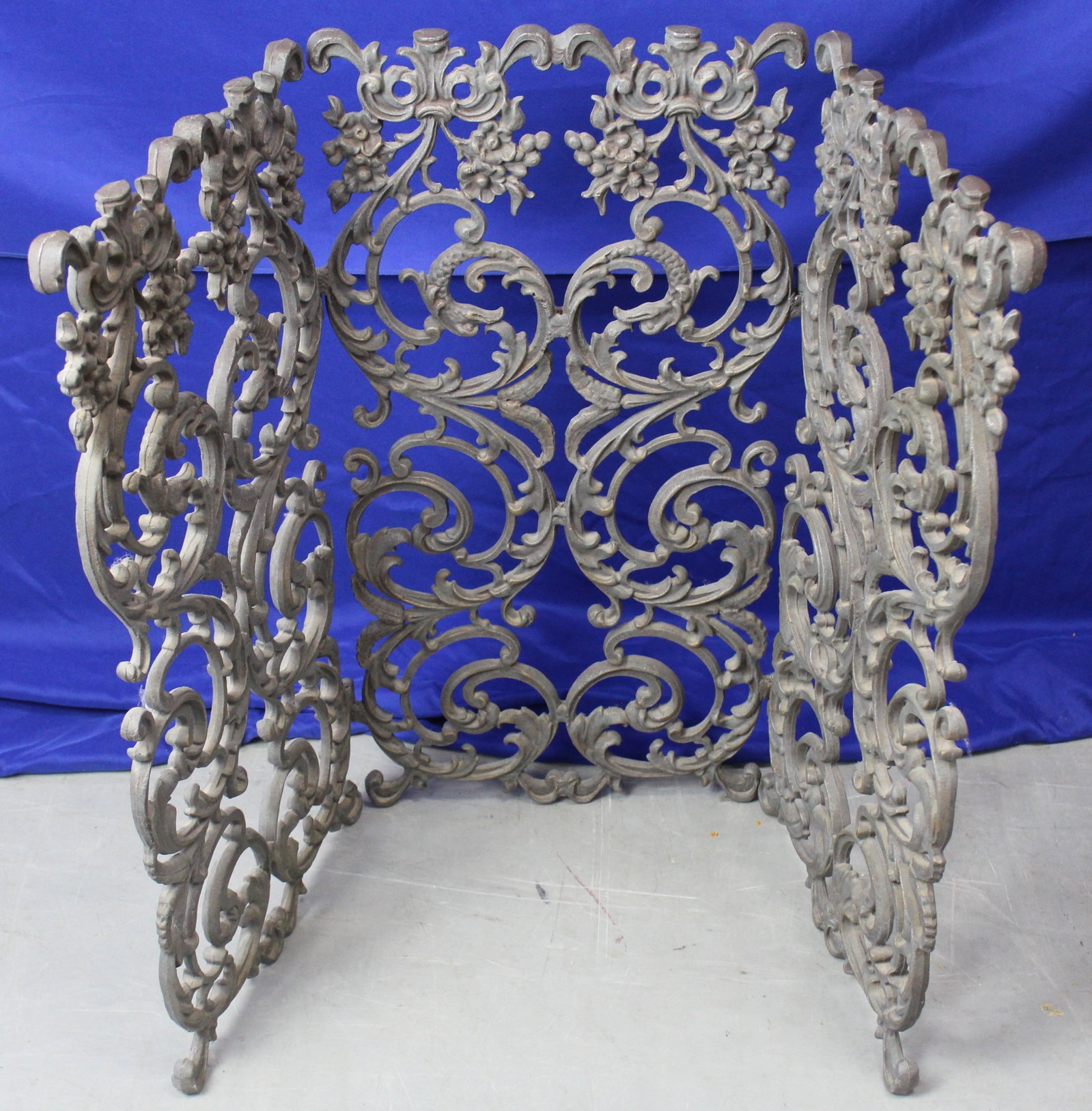 Wrought Iron Floral Fireplace Screen: Iron fireplace screen with three sections, two of which fold. The screen has beautiful repeating floral designs. Overall the screen is in excellent condition. When closed, the screens are 33.25" tall