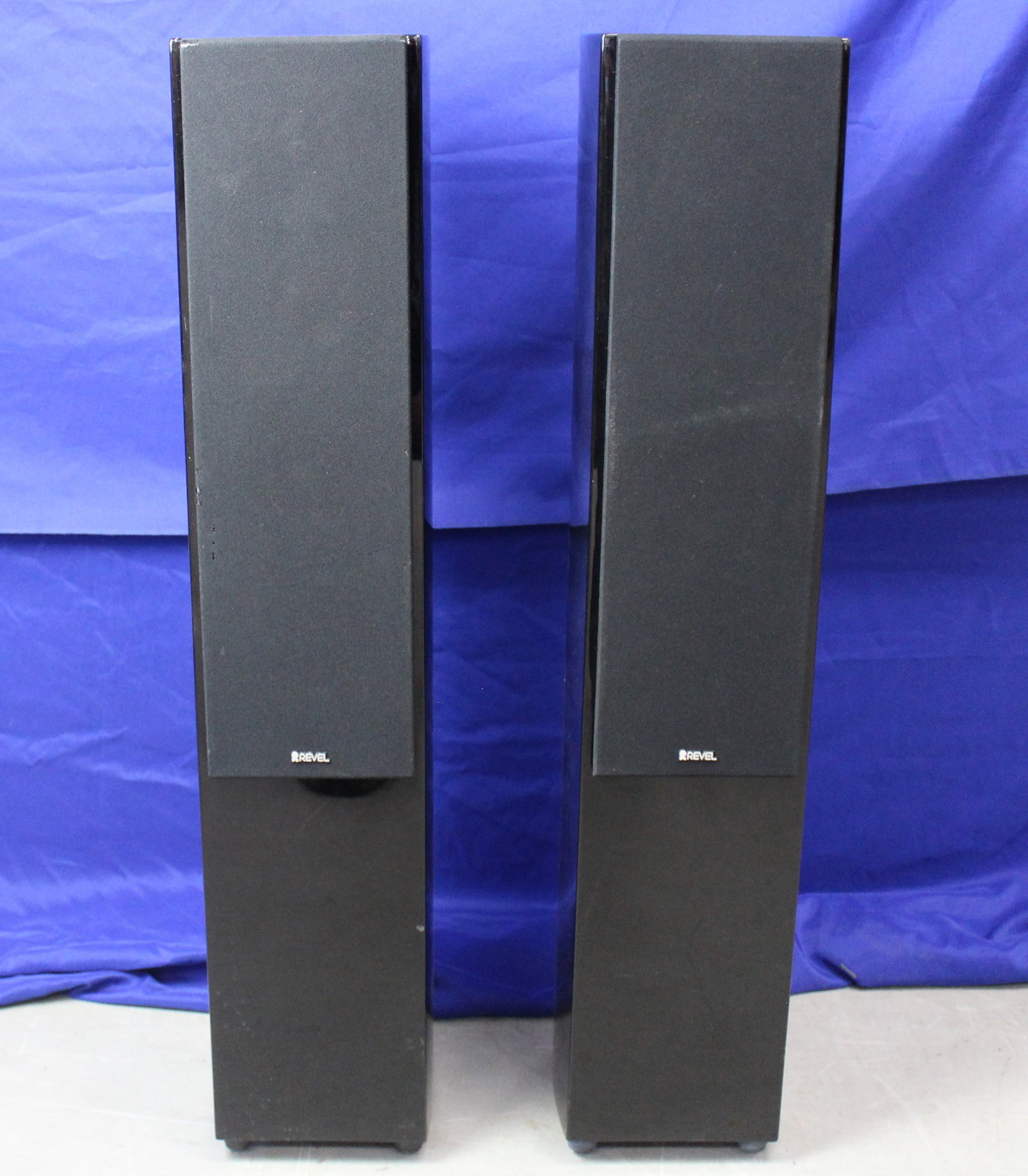 Revel Concerta F35 Speakers: Concerta F35 Tower speakers by Revel with a glossy black finish. Each speaker has 4 drivers, 1 tweeter and 3 midrange drivers. The speakers have magnetic grills and are functioning as they should;