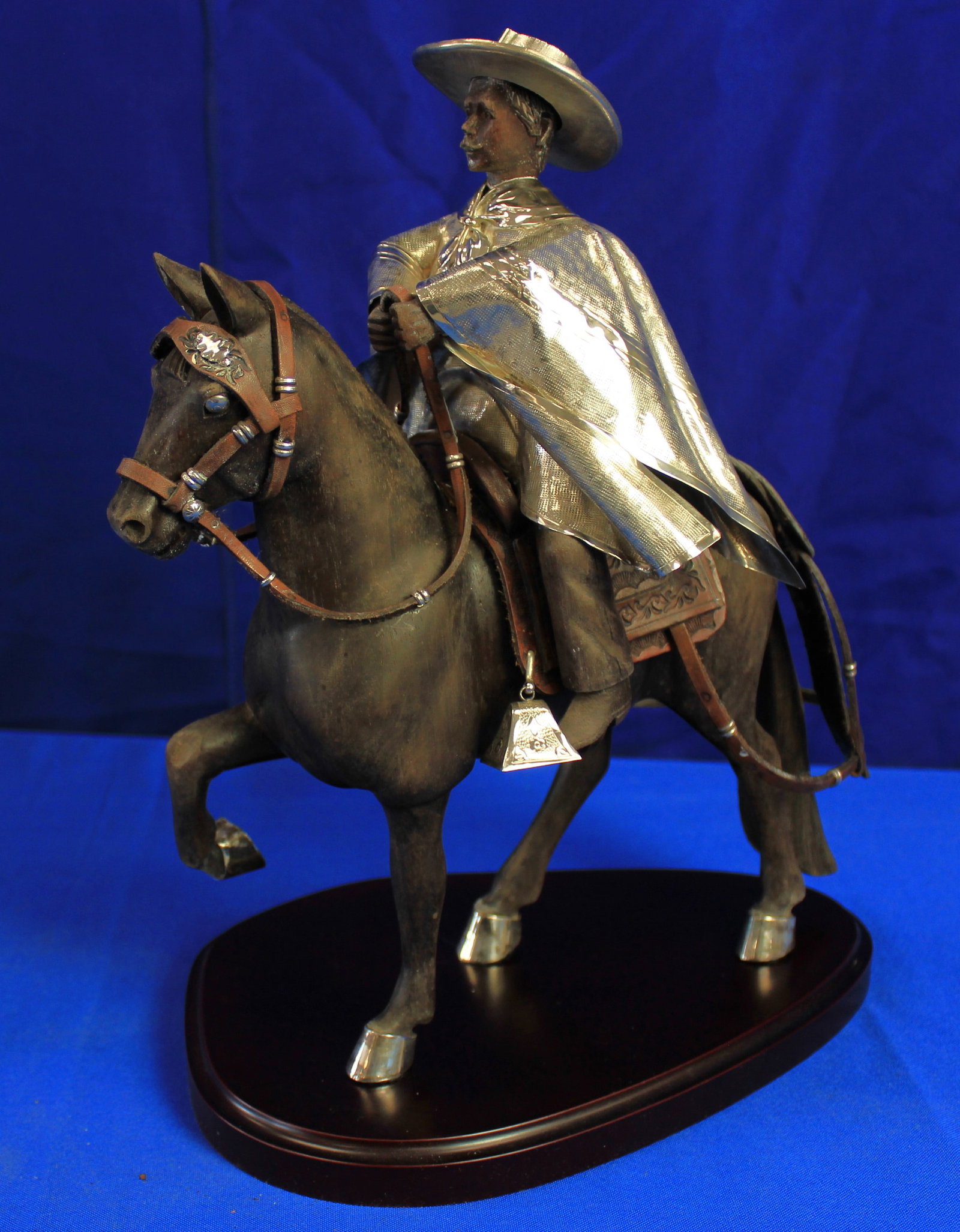 Ilaria Sterling Silver Chalan Horseman on a Wood Paso Horse: Wooden Paso horse and Chalan horsemen with a Ilaria sterling silver hat and outfit. The horse has sterling silver hoofs, stirrups, and other small accents. The bottom of the horse is labeled Ilaria