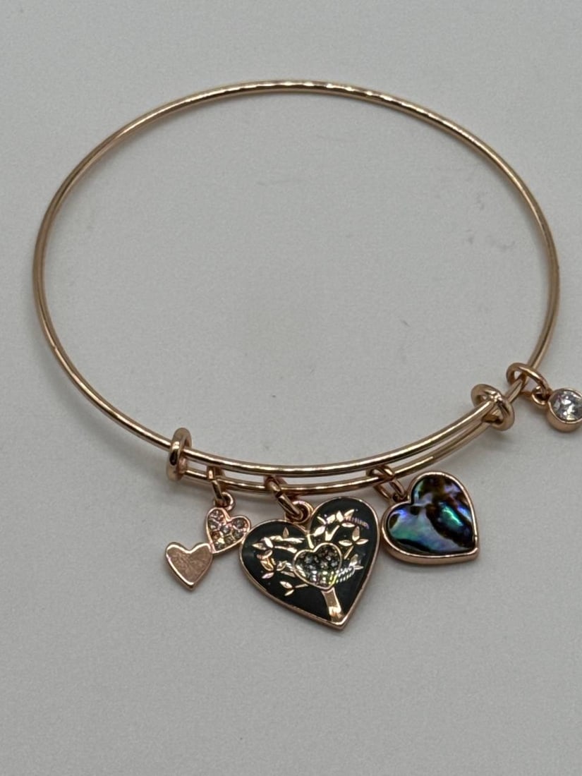Unbranded Heart Charm Bracelet with Crystal Accents 2.5 in: This elegant bangle bracelet features a delicate design adorned with charming heart pendants and sparkling crystal accents. The bracelet showcases intricately detailed charms, one of which beautifully