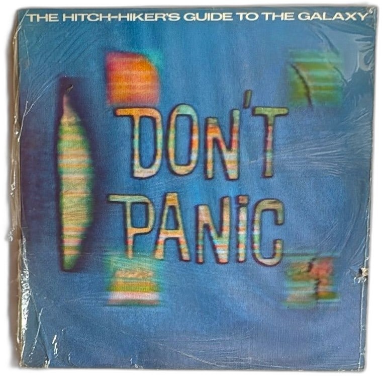 Hitchhikers Guide To The Galaxy Original 1979 Vinyl LP ORA42 BBC Radio Import: The Hitchhiker's Guide to the Galaxy original 1979 vinyl LP, ORA42, based on the BBC Radio 4 series by Douglas Adams. Iconic cover art with "Don't Panic" on blue background, made by Original Records L