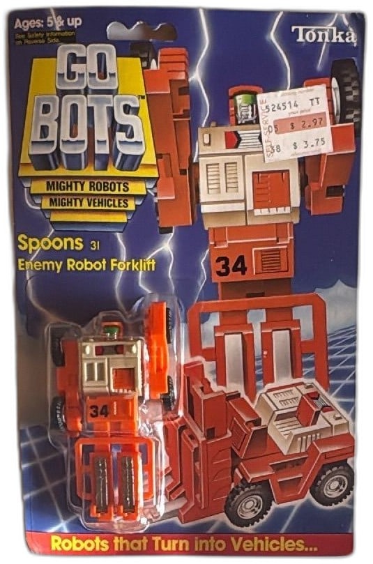 Tonka GoBots Spoons 31 Enemy Robot Forklift 1984 Sealed Original Card: Tonka GoBots Spoons 31 Enemy Robot Forklift, sealed on original 1984 card. Collectible vintage transforming figure in bright orange with silver details, shows enemy robot forklift theme. Packaging dis
