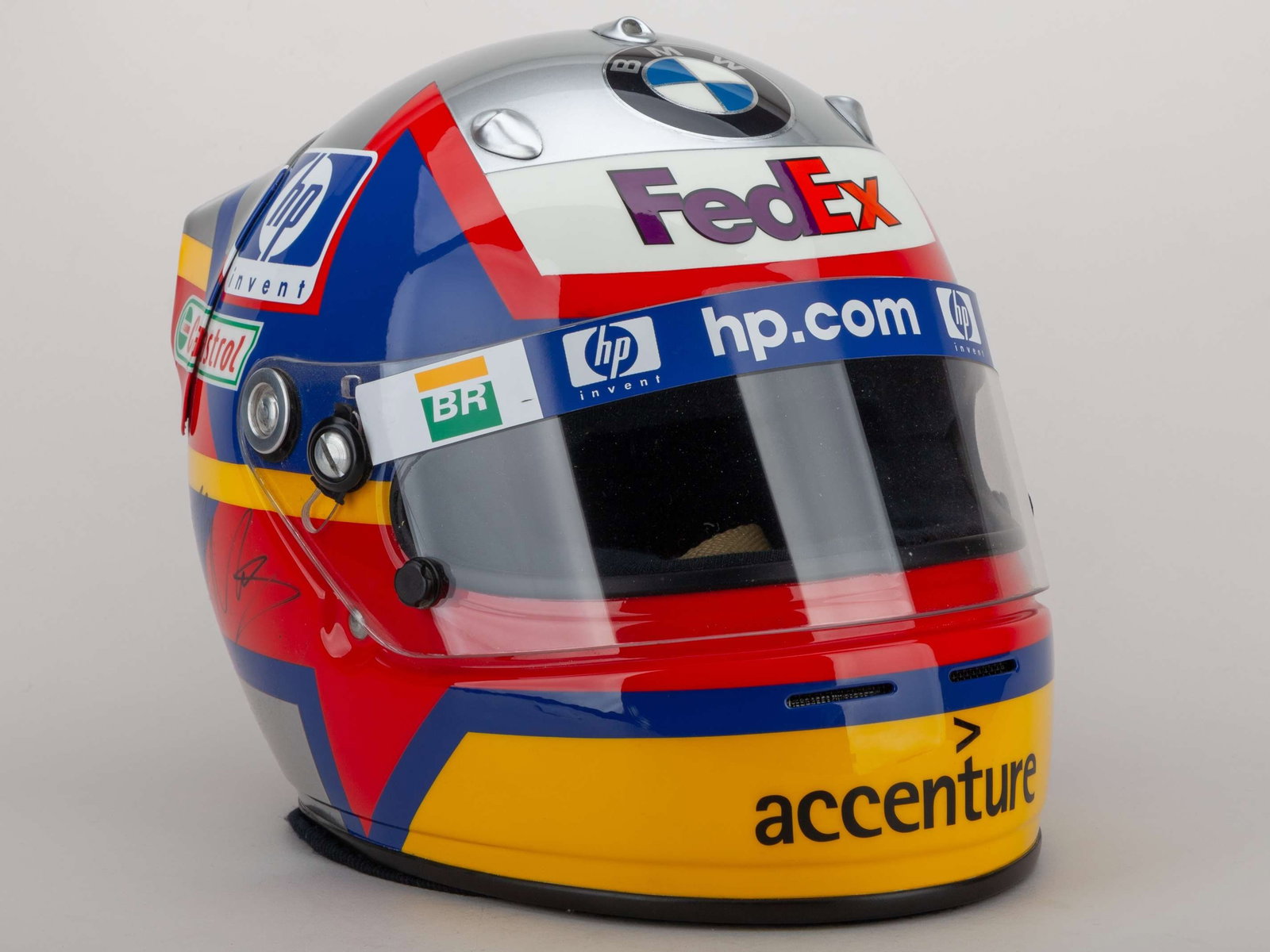 A Juan Pablo Montoya autographed Arai helmet with sponsors logos.: A Juan Pablo Montoya autographed silver, red, yellow and blue Arai helmet with sponsors logos, the side of the helmet autographed by JP Montoya.