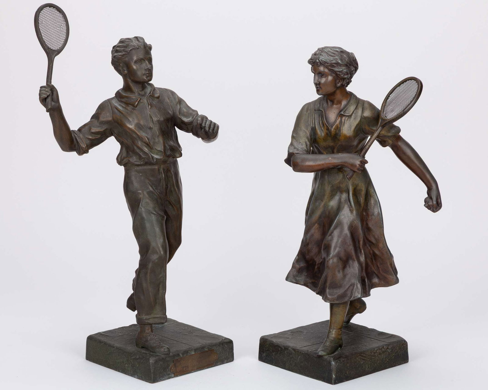 A pair of matched, very detailed possibly from the 1920s showing a male and female player: A pair of matched, very detailed possibly from the 1920s showing a male and female player in action, the bases signed Ruffony, France, with fine mesh wire used to define the racket strings, the male f