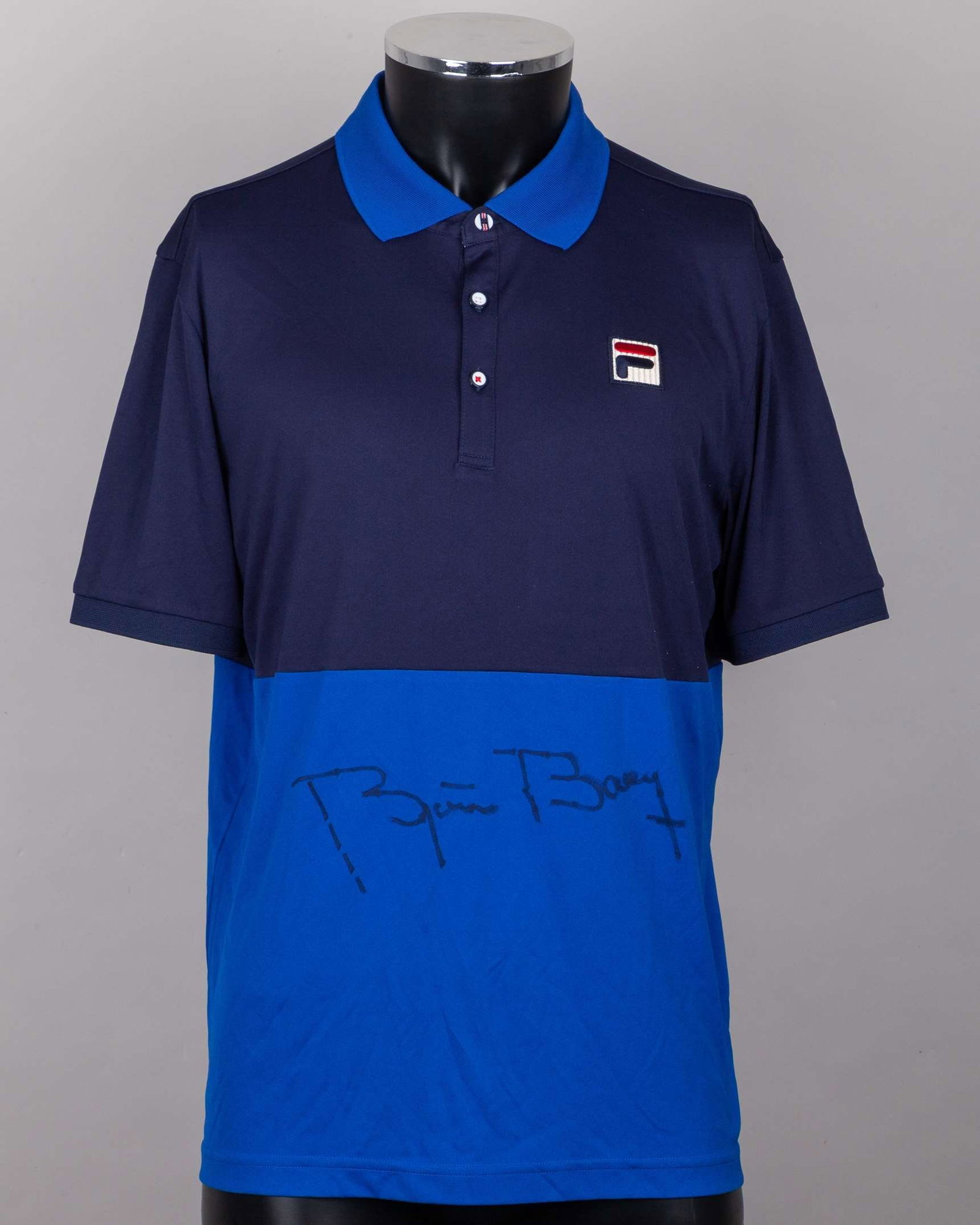 A blue Fila tennis shirt autographed by Bjorn Borg: A blue Fila tennis shirt autographed by Bjorn Borg, UK XL, with button-up collar and embroidered F badge The signed shirt was gifted to the OSPA Cabo Verde Cats and Dogs Rescue Centre by Bjorn B