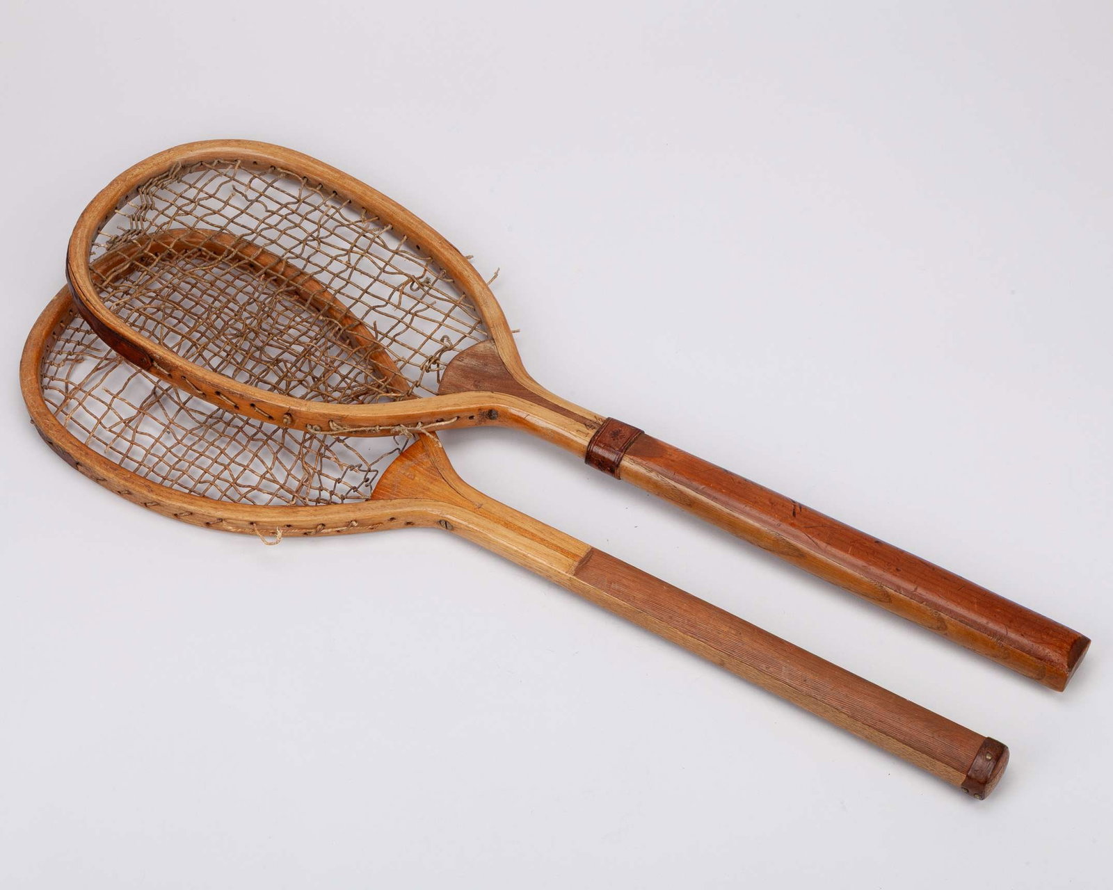 A Wrinch & Sons early offset lawn tennis racket: A Wrinch & Sons early offset lawn tennis racket, stamped Wrinch & Sons, 2 Manufacturers Ipswich, with narrow handle, long centre wedge, with leather handle piece and slightly bulbous end and remains