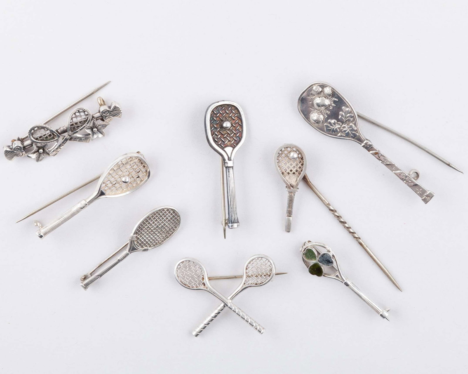 Two silver tennis related brooches, 1893 and 1895: Two silver tennis related brooches, 1893 and 1895, five other white-metal tennis related brooches and white-metal tiepin (8) 