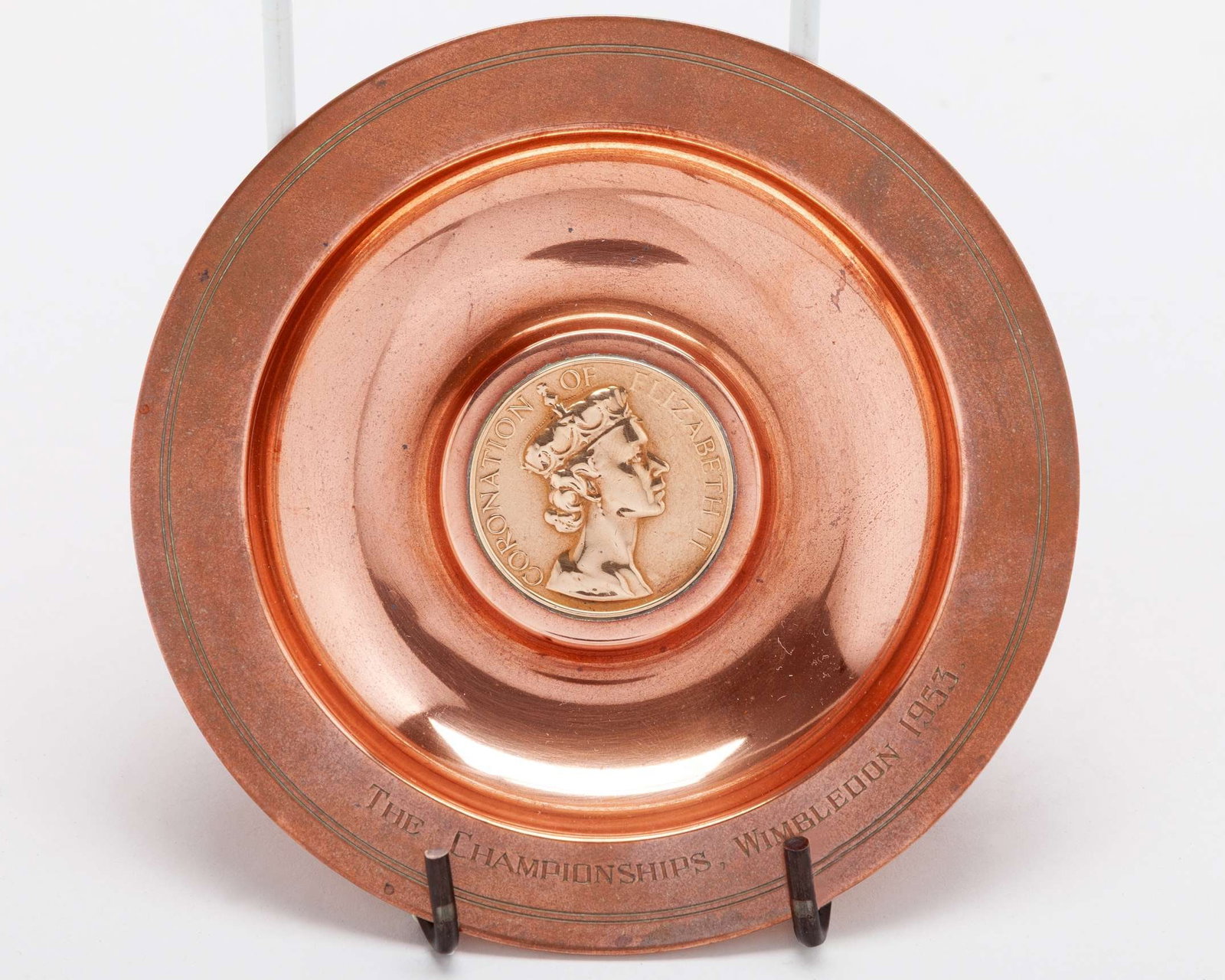 A copper dish commemorating the Coronation Championships at Wimbledon in 1953: A copper dish commemorating the Coronation Championships at Wimbledon in 1953, set with a coin to the centre, silver and enamel Royal Box lapel badge, 2015, two enamel steward badges, other badges,