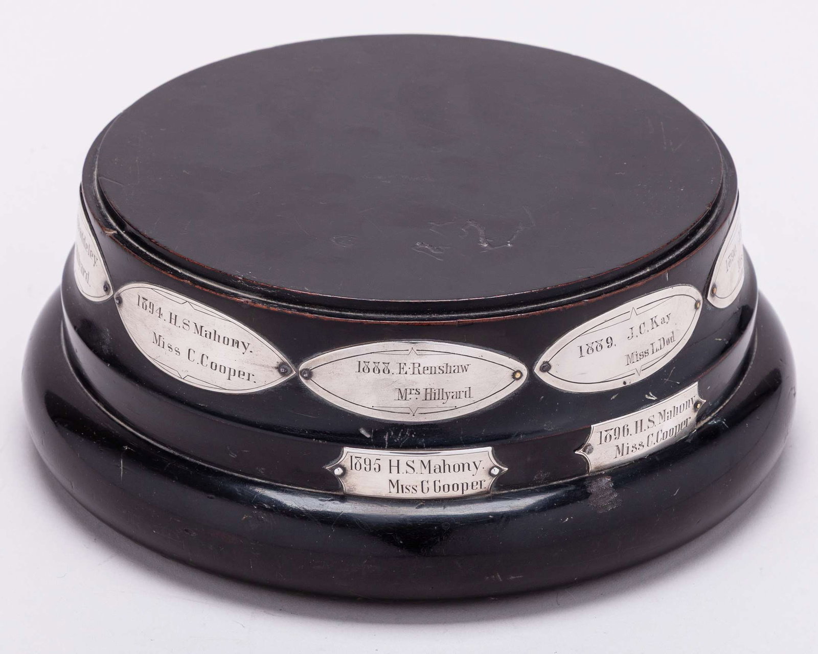 A turned ebony trophy base The All England Mixed Doubles: A turned ebony trophy base The All England Mixed Doubles, the base with white-metal plaque inscribed All England Mixed Doubles Championship Gentleman's Cup, with further seven oval plaques and two rec
