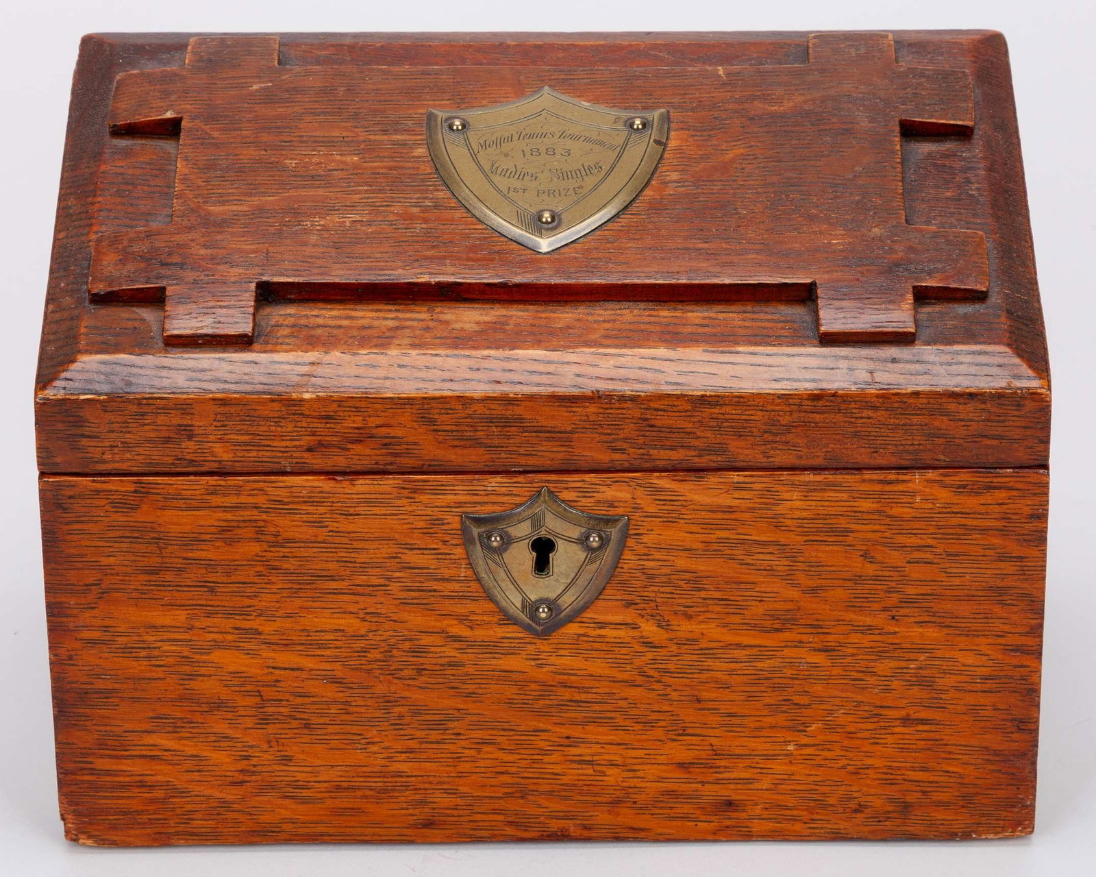 A first prize for the “Moffat Tennis Tournament, Ladies' Singles, 1883: A first prize for the “Moffat Tennis Tournament, Ladies' Singles, 1883, in the form of a hinged oak box with an engraved presentation brass shield, with a matching brass escutcheon to the front