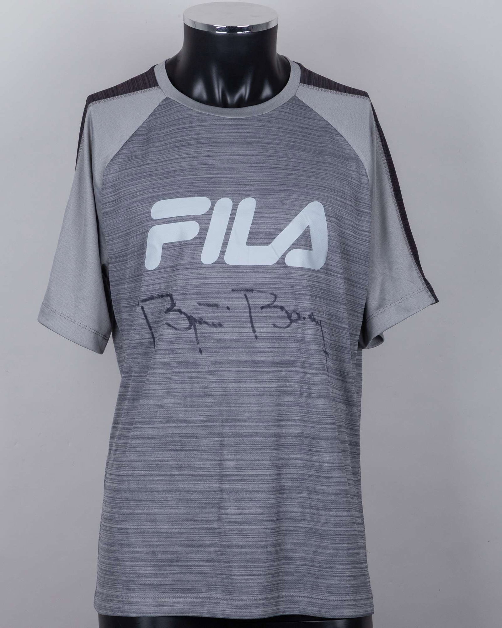 A grey Fila tennis shirt autographed by Bjorn Borg, UK XL, with crew-neck collar: A grey Fila tennis shirt autographed by Bjorn Borg, UK XL, with crew-neck collar and FILA decal The signed shirt was gifted to the OSPA Cabo Verde Cats and Dogs Rescue Centre by Bjorn Borg, he a