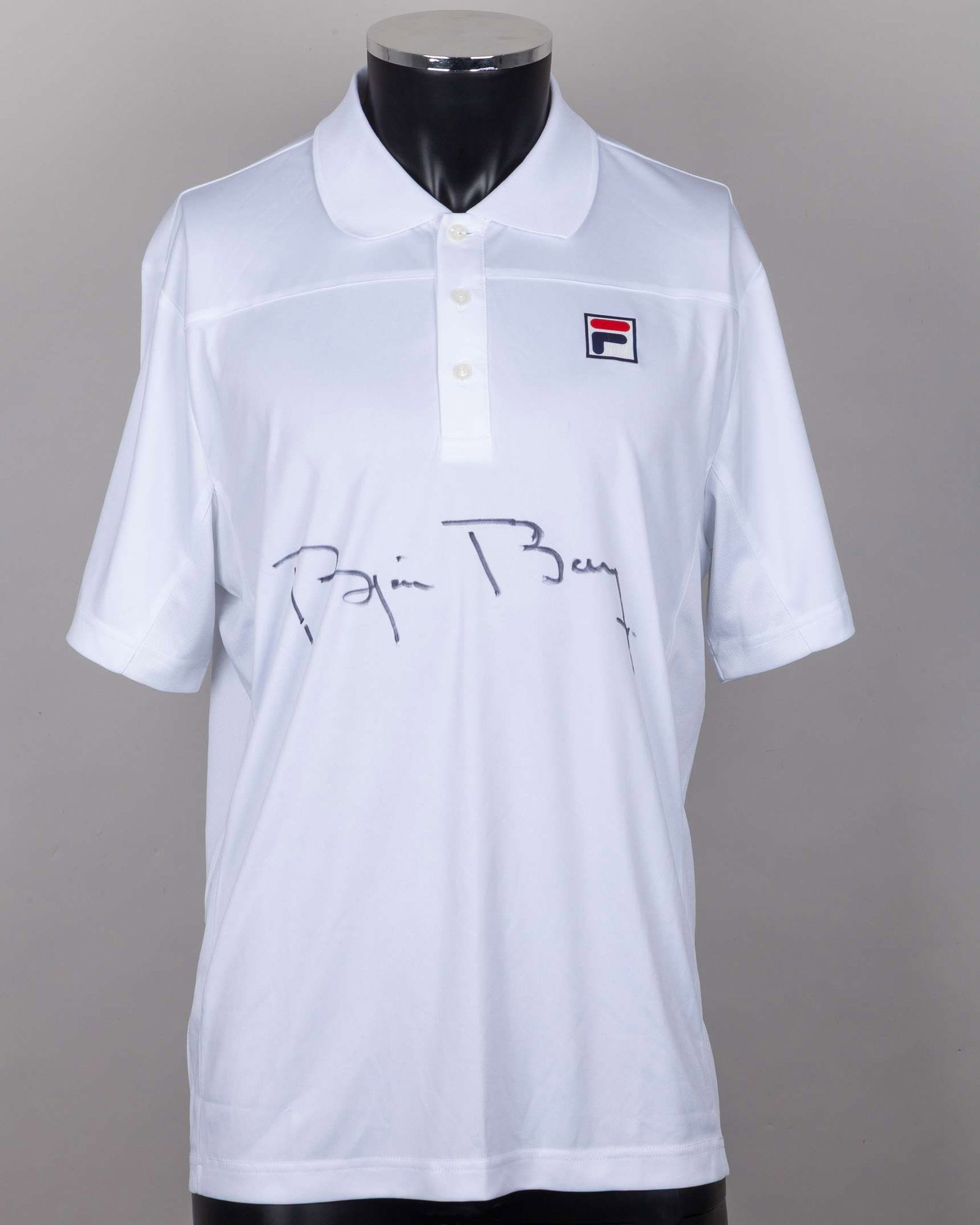 A white Fila tennis shirt autographed by Bjorn Borg, UK XL, with button-up collar: A white Fila tennis shirt autographed by Bjorn Borg, UK XL, with button-up collar and printed F badge The signed shirt was gifted to the OSPA Cabo Verde Cats and Dogs Rescue Centre by Bjorn Borg