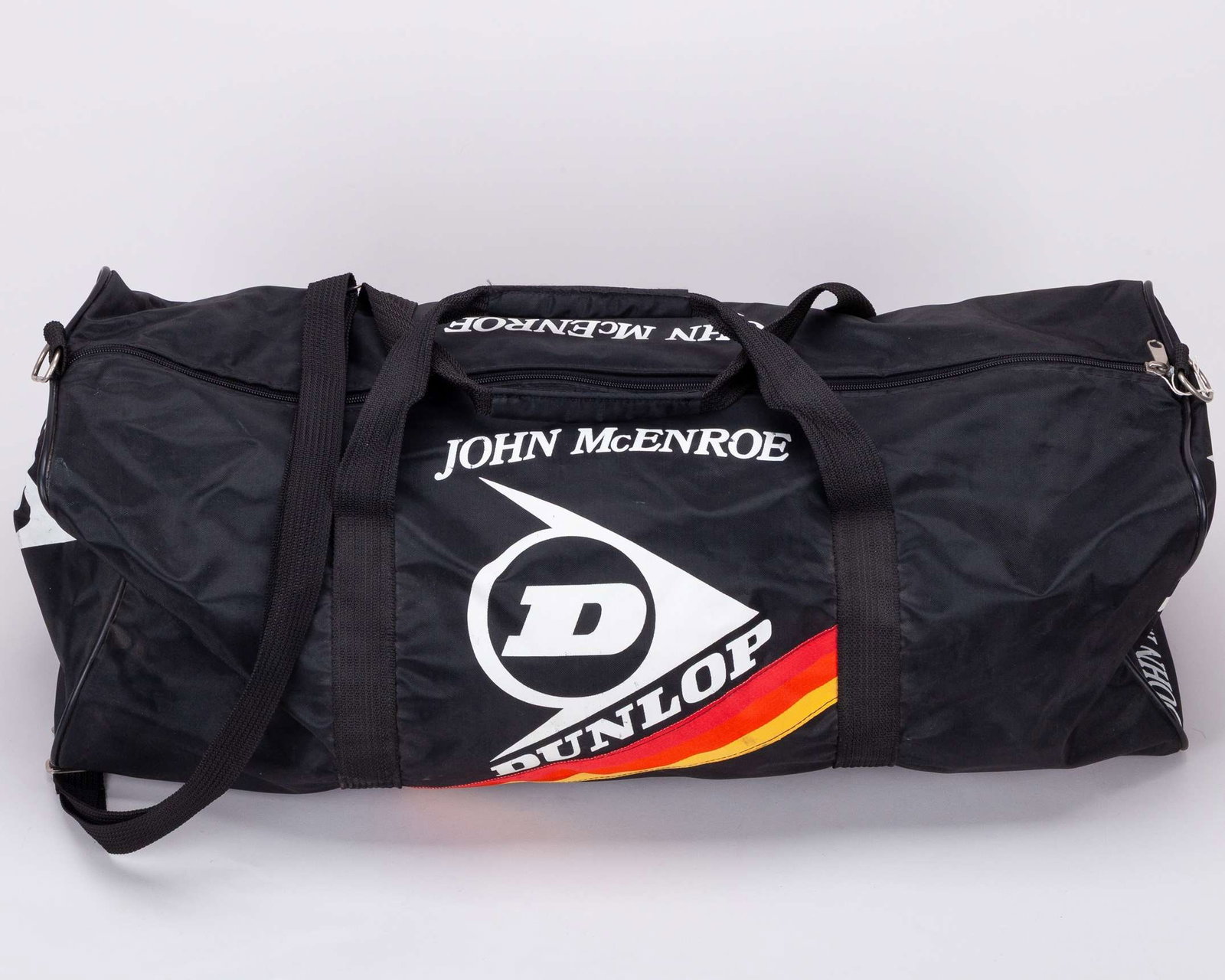John McEnroe black Dunlop equipment duffle bag: John McEnroe black Dunlop equipment duffle bag, inscribed on all sides JOHN McENROE The bag was gifted to a staff member of the residency McEnroe would regularly stay at during Wimbledon 