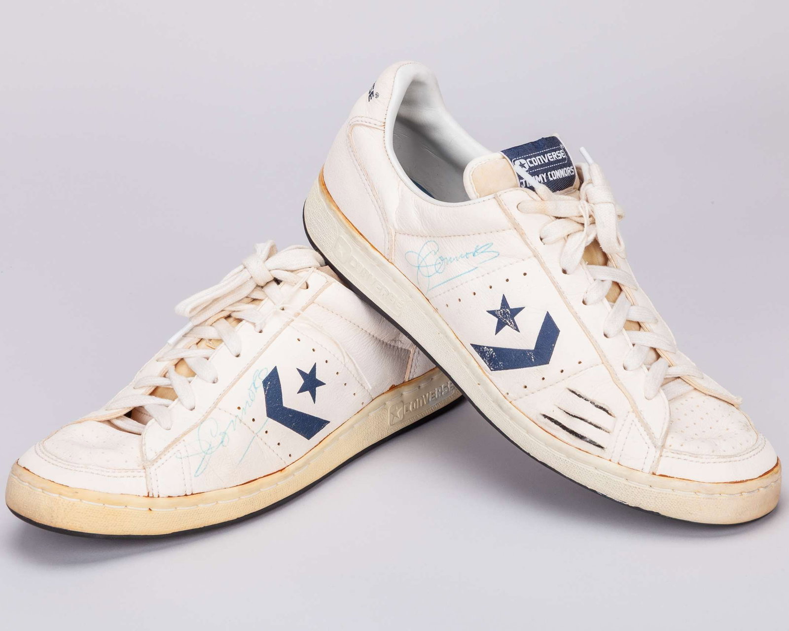 Pair of Jimmy Connors autographed white Jimmy Connors Converse trainers: Pair of Jimmy Connors autographed white Jimmy Connors Converse trainers, right trainer with three cuts on the front right to create a vent, with some discolouration and rubbing 