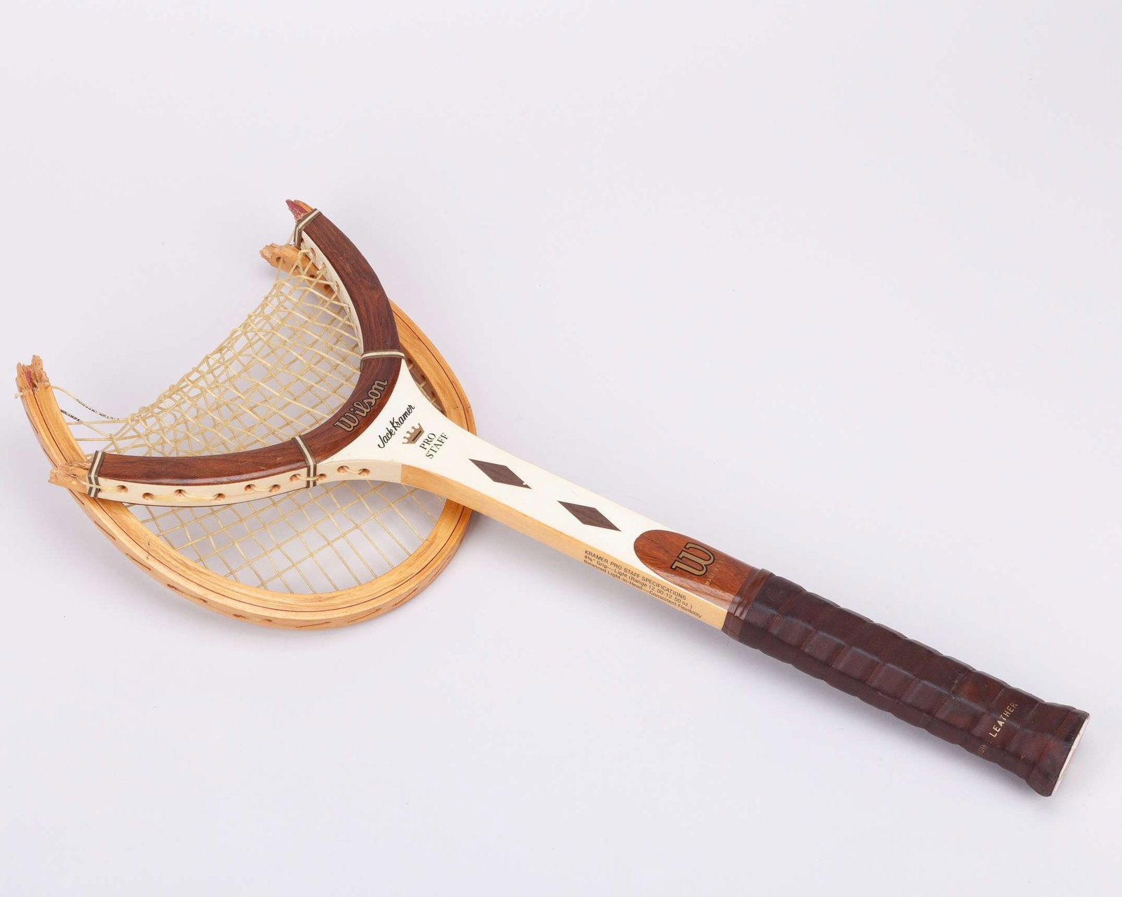 John McEnroe smashed Wilson Jack Kramer Pro Staff wooden tennis racket, Wimbledon c.1977-80: John McEnroe smashed Wilson Jack Kramer Pro Staff wooden tennis racket, Wimbledon c.1977-80, made in U.S.A., with 4 5/8" grip, broken on both sides of the head and held together with the strings 